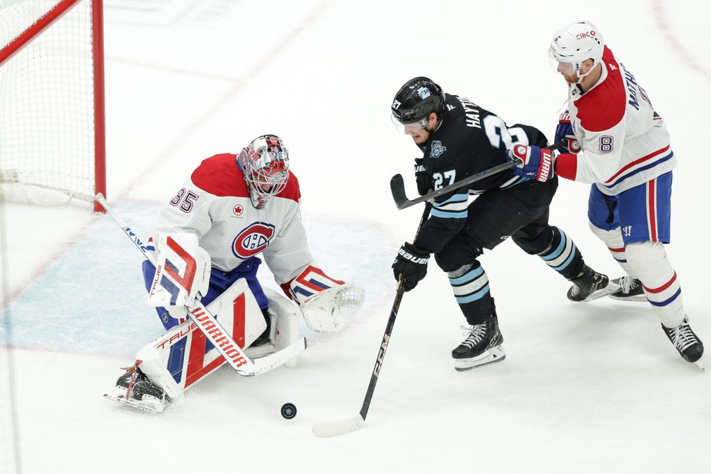 Jan 14, 2025; Salt Lake City, Utah, USA; Utah Hockey Club center Barrett Hayton (27) tries to push the puck past Montreal Canadiens goaltender Sam Montembeault (35) during the second period at Delta Center. Mandatory Credit: Chris Nicoll-Imagn Images