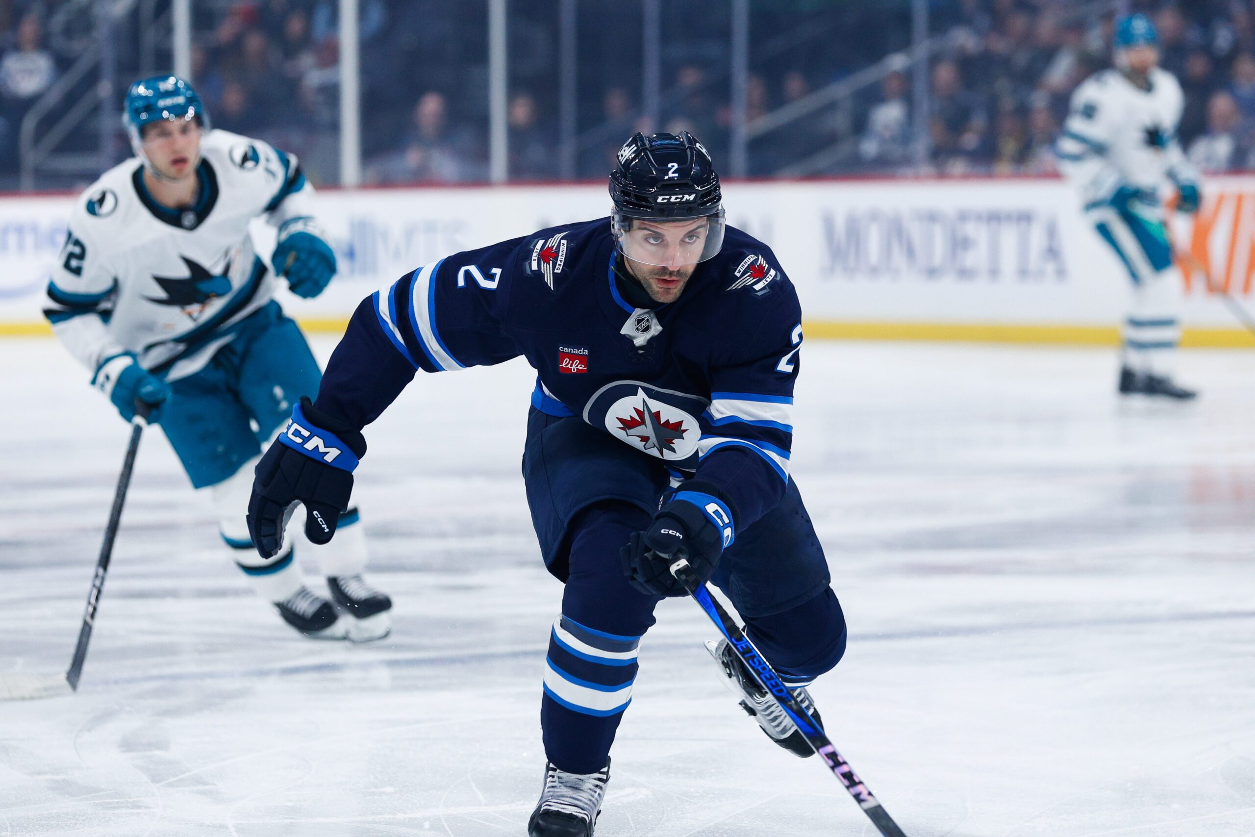 Feb 24, 2025; Winnipeg, Manitoba, CAN;  Winnipeg Jets defenseman Dylan DeMelo (2) skates after the puck against the San Jose Sharks during the first period at Canada Life Centre. Mandatory Credit: Terrence Lee-Imagn Images