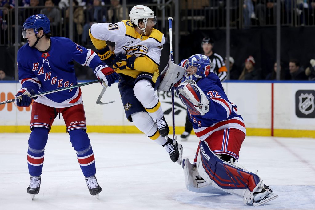 Mar 2, 2025; New York, New York, USA; New York Rangers goaltender Jonathan Quick (32) plays the puck in front of Nashville Predators center Tommy Novak (82) and Rangers defenseman Will Borgen (17) during the first period at Madison Square Garden. Mandatory Credit: Brad Penner-Imagn Images
