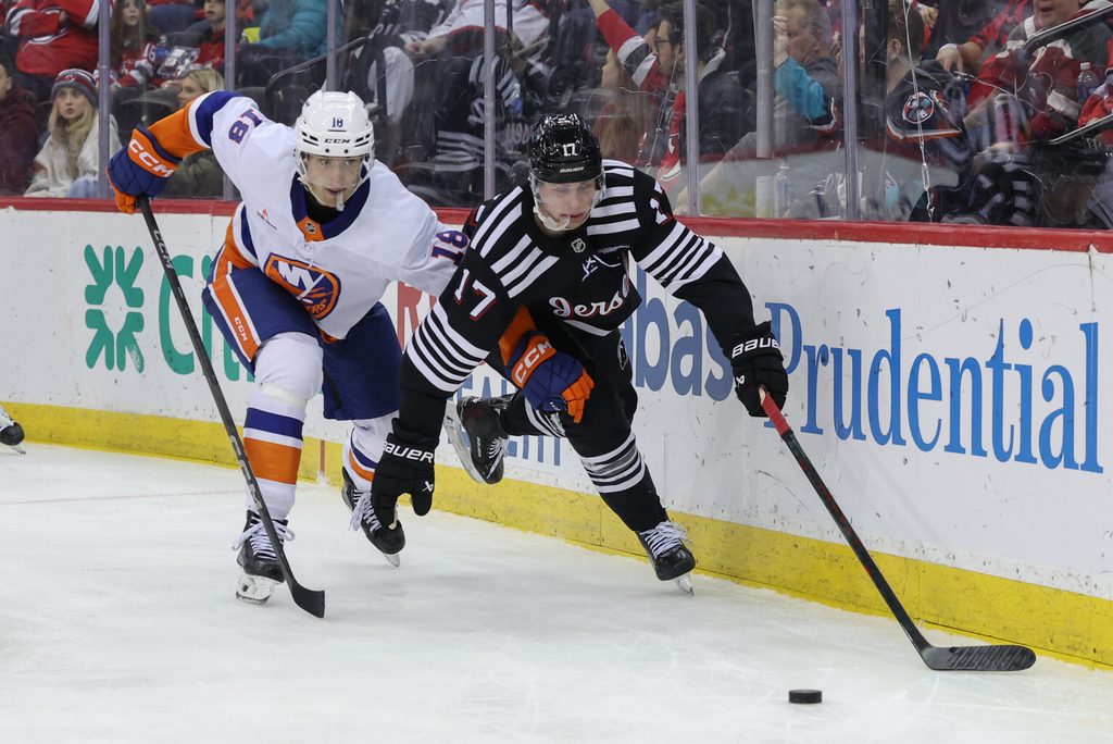 Apr 13, 2025; Newark, New Jersey, USA; New Jersey Devils defenseman Simon Nemec (17) and New York Islanders left wing Pierre Engvall (18) battle for the puck during the third period at Prudential Center. Mandatory Credit: Ed Mulholland-Imagn Images