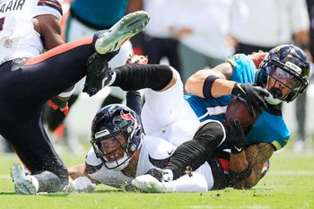 Jacksonville Jaguars wide receiver Parker Washington (11), right, hauls in a reception against Houston Texans linebacker Azzez Al-Shaair (0) and linebacker Henry To'Oto'O (39), bottom, during the first quarter of an NFL football matchup at EverBank Stadium, Sunday, Sept. 21, 2025, in Jacksonville, Fla. The Jaguars defeated the Texans 17-10.
