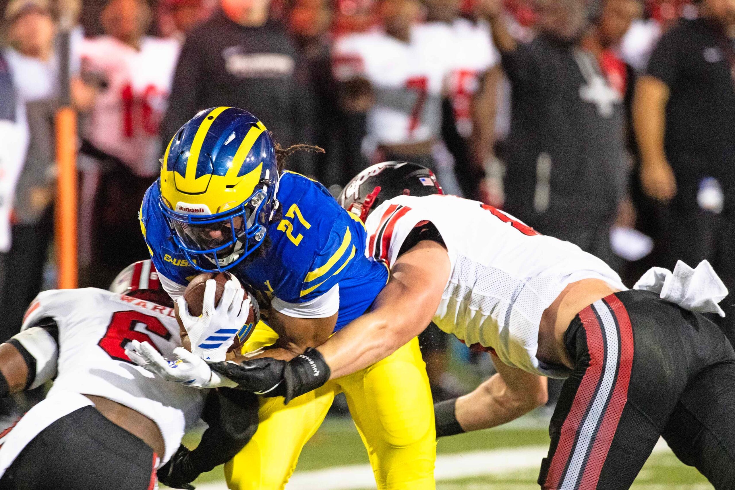 Delaware Blue Hens running back Jo Silver (27) hangs on to the ball as he is flanked by Western Kentucky defensive back Nazir Ward (6) and linebacker Miller Malone (8) for the takedown during Delaware's first home CUSA football game, which was nationally televised, at Delaware Stadium in Newark on Oct. 3, 2025. Western Kentucky won 27-24.