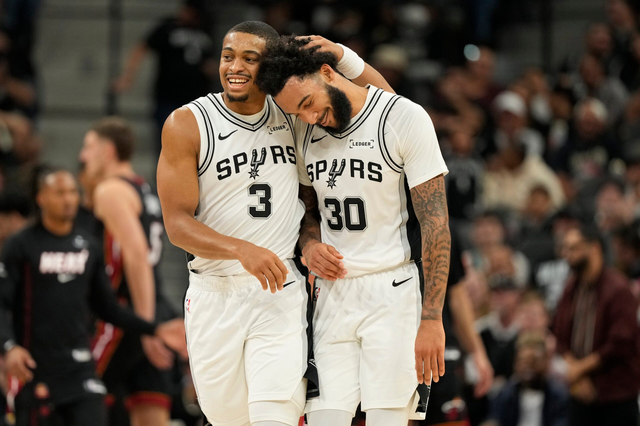 Oct 30, 2025; San Antonio, Texas, USA; San Antonio Spurs forward Keldon Johnson (3) and forward Julian Champagnie (30) react after the first quarter against the Miami Heat at Frost Bank Center. Mandatory Credit: Scott Wachter-Imagn Images