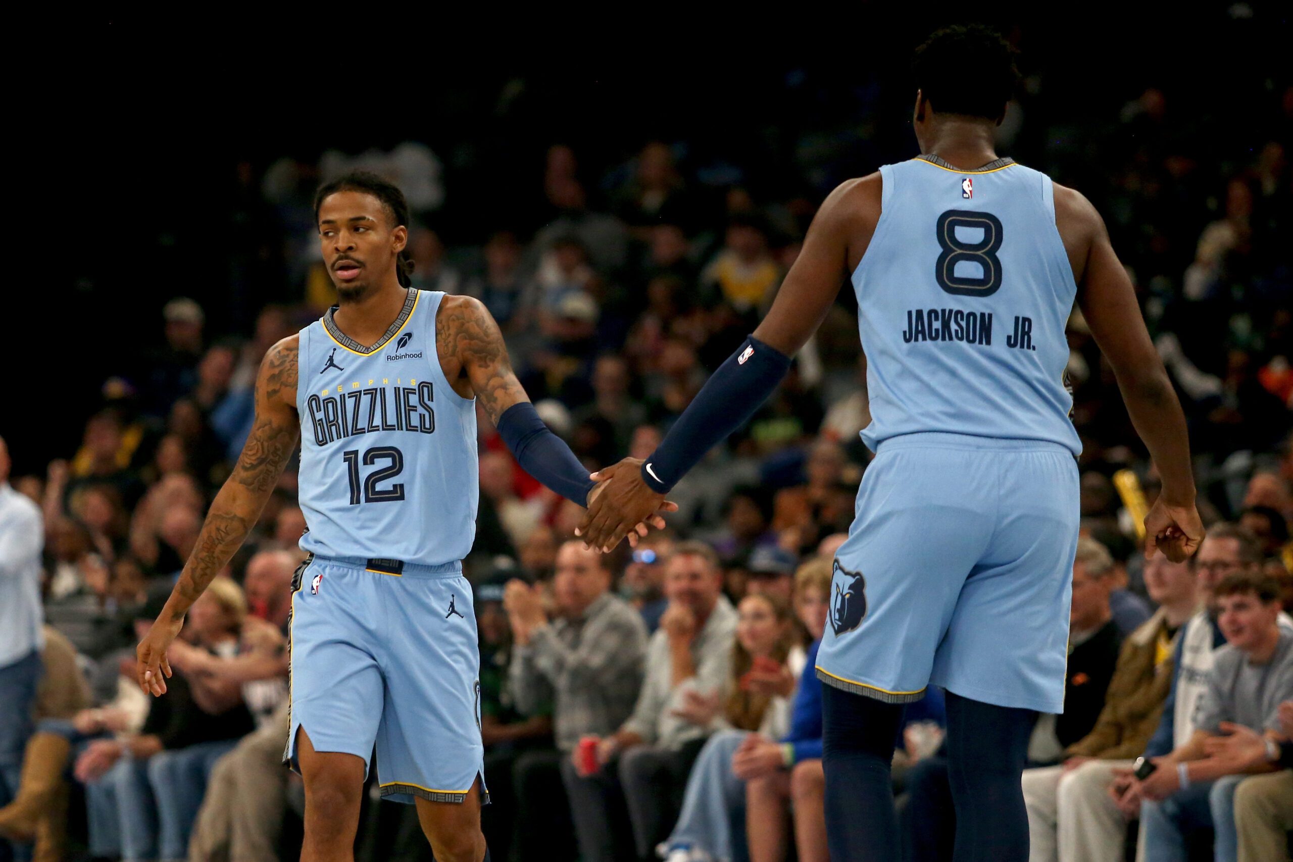 Oct 31, 2025; Memphis, Tennessee, USA; Memphis Grizzlies guard Ja Morant (12) reacts with forward/center Jaren Jackson Jr. (8) during the first quarter against the Los Angeles Lakers at FedExForum. Mandatory Credit: Petre Thomas-Imagn Images