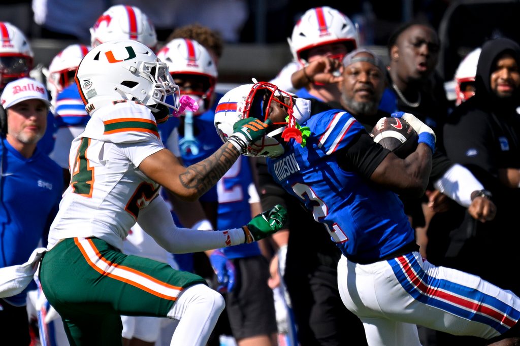 Nov 1, 2025; Dallas, Texas, USA; SMU Mustangs wide receiver Jordan Hudson (2) catches a pass for a first down as he is tackled by Miami Hurricanes defensive back Ethan O'Connor (24) during the second half at Gerald J. Ford Stadium. Mandatory Credit: Jerome Miron-Imagn Images