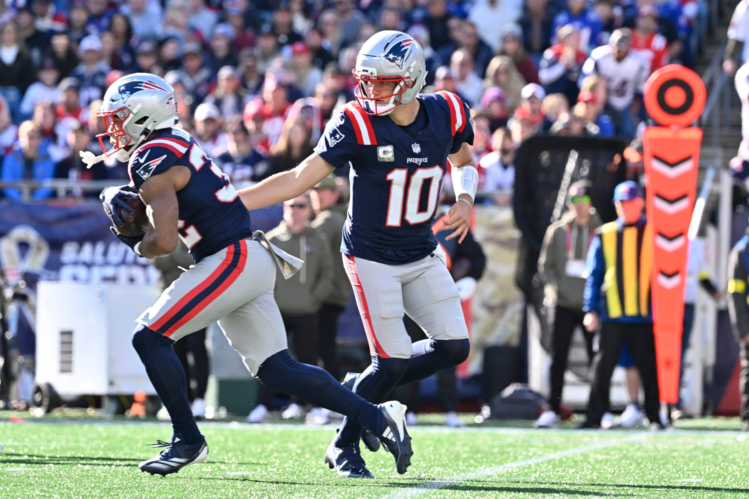 Nov 2, 2025; Foxborough, Massachusetts, USA; New England Patriots quarterback Drake Maye (10) hands the ball off to running back TreVeyon Henderson (32) during the first quarter at Gillette Stadium. Mandatory Credit: Eric Canha-Imagn Images