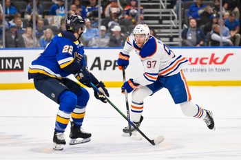 Nov 3, 2025; St. Louis, Missouri, USA; Edmonton Oilers center Connor McDavid (97) controls the puck as St. Louis Blues center Pius Suter (22) defends during the first period at Enterprise Center. Mandatory Credit: Jeff Curry-Imagn Images