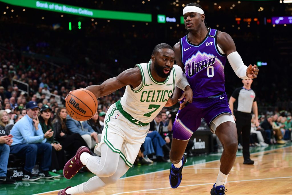 Nov 3, 2025; Boston, Massachusetts, USA; Boston Celtics guard Jaylen Brown (7) controls the ball while Utah Jazz forward Taylor Hendricks (0) defends during the first half at TD Garden. Mandatory Credit: Bob DeChiara-Imagn Images
