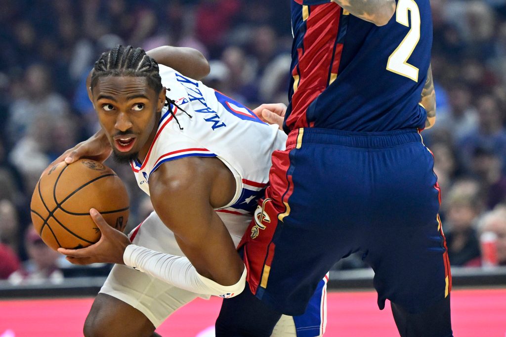 Nov 5, 2025; Cleveland, Ohio, USA; Philadelphia 76ers guard Tyrese Maxey (0) looks to pass beside Cleveland Cavaliers guard Lonzo Ball (2) in the first quarter at Rocket Arena. Mandatory Credit: David Richard-Imagn Images