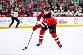 Nov 8, 2025; Newark, New Jersey, USA; New Jersey Devils center Nico Hischier (13) passes the puck against the Pittsburgh Penguins during the first overtime period at Prudential Center. Mandatory Credit: John Jones-Imagn Images