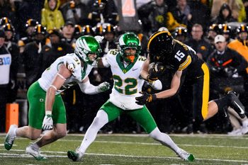 Iowa Hawkeyes wide receiver Reece Vander Zee (15) is stopped by Oregon Ducks defensive back Dillon Thieneman (31) and Oregon Ducks defensive back Jadon Canady (22) Nov. 8, 2025 during a Big Ten Football game at Kinnick Stadium in Iowa City, Iowa.