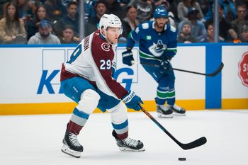 Nov 9, 2025; Vancouver, British Columbia, CAN; Colorado Avalanche forward Nathan MacKinnon (29) handles the puck against the Vancouver Canucks in the first period at Rogers Arena. Mandatory Credit: Bob Frid-Imagn Images