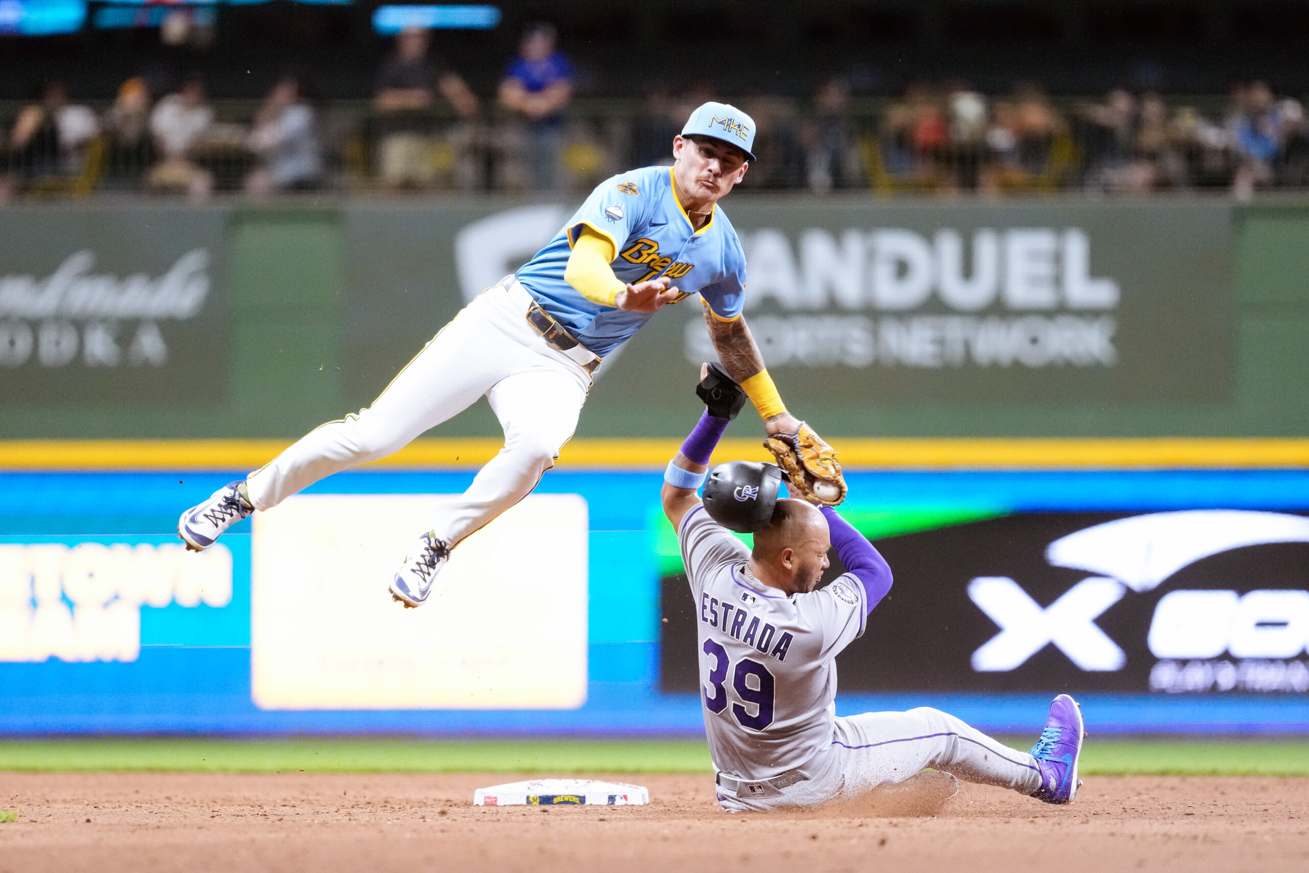 Jun 27, 2025; Milwaukee, Wisconsin, USA;  Colorado Rockies second baseman Thairo Estrada (39) is tagged out but Milwaukee Brewers shortstop Joey Ortiz (3) while trying to steal second base during the seventh inning at American Family Field. Mandatory Credit: Jeff Hanisch-Imagn Images