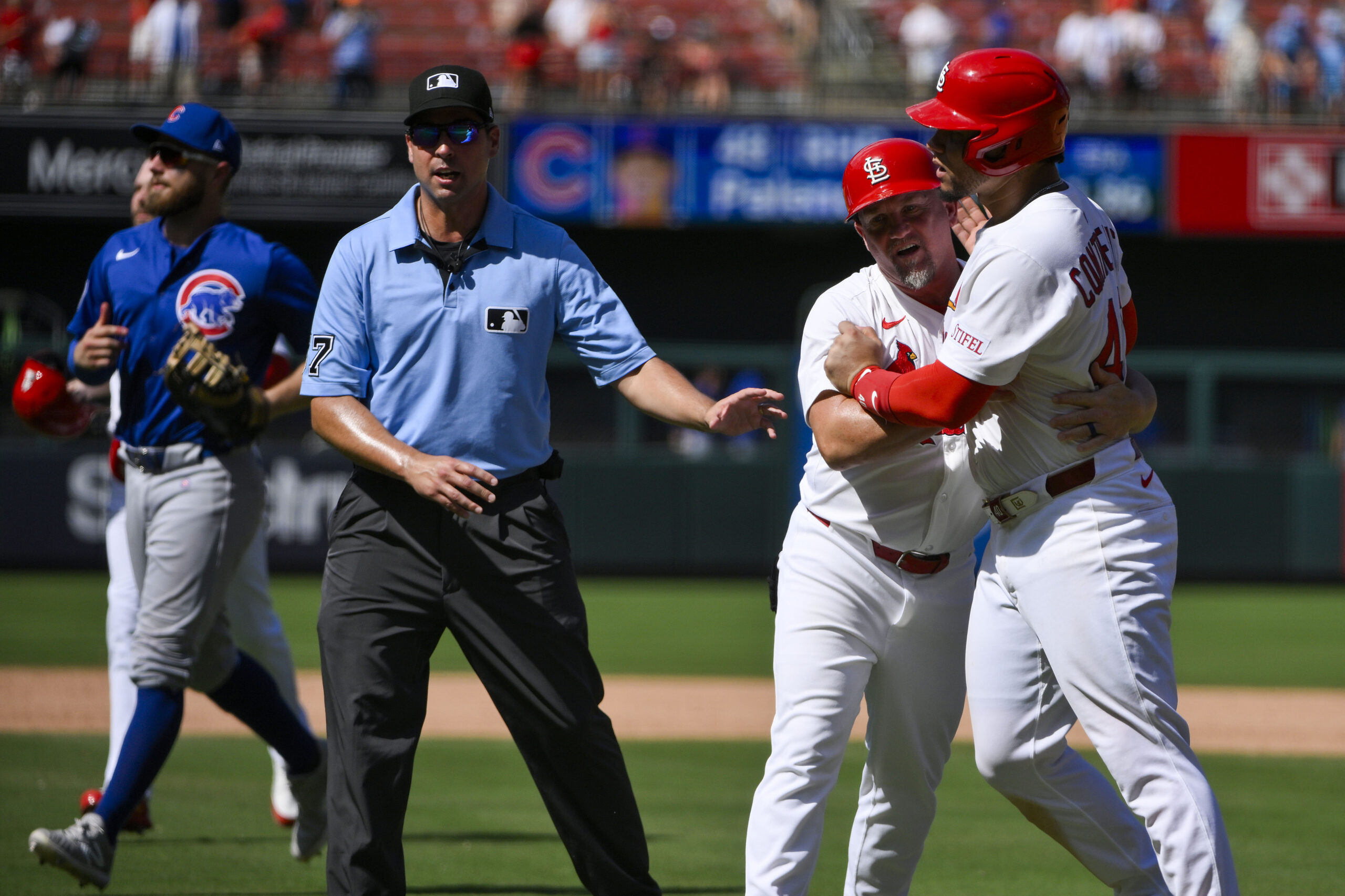 Jun 26, 2025; St. Louis, Missouri, USA;  St. Louis Cardinals first baseman Willson Contreras (40) is held back by first base coach Stubby Clapp (82) as he exchanges words with Chicago Cubs relief pitcher Daniel Palencia (not pictured) after the Cubs defeated the Cardinals at Busch Stadium. Mandatory Credit: Jeff Curry-Imagn Images