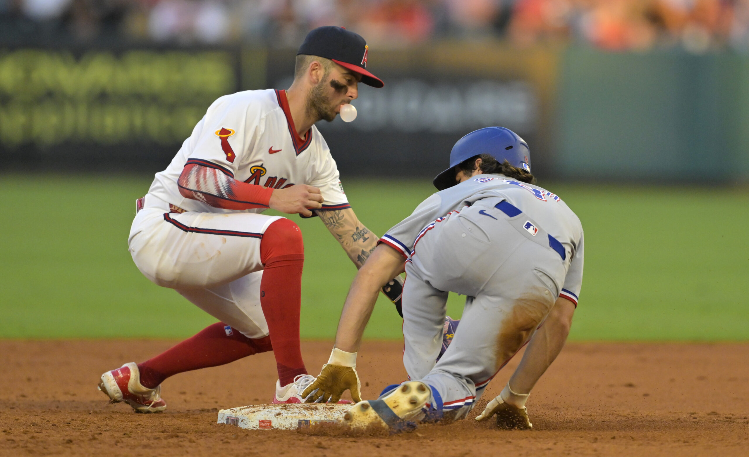 Jul 9, 2025; Anaheim, California, USA;  Texas Rangers shortstop Josh Smith (8) beats the tag by Los Angeles Angels shortstop Zach Neto (9) for a stolen base in the fourth inning at Angel Stadium. Mandatory Credit: Jayne Kamin-Oncea-Imagn Images