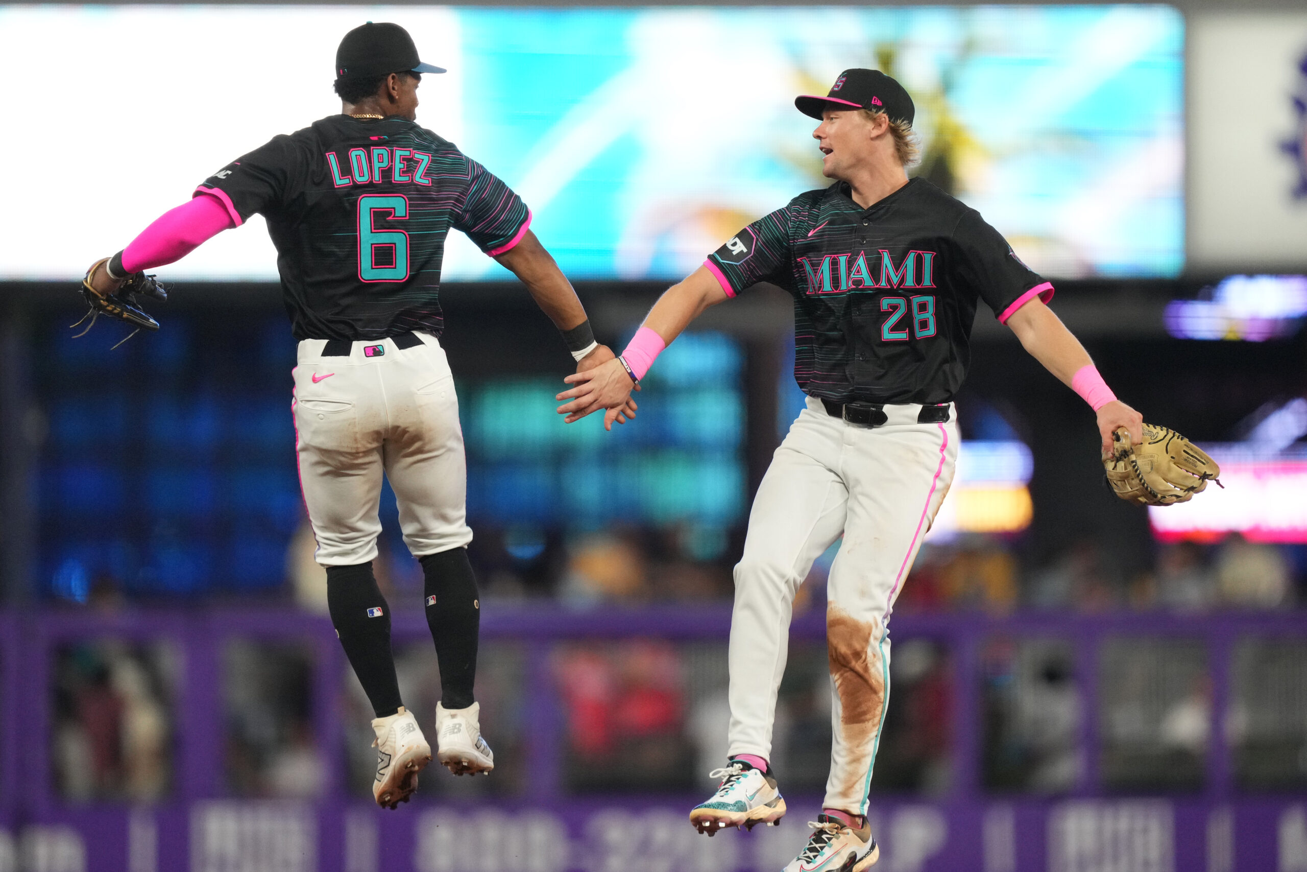 Jul 19, 2025; Miami, Florida, USA; Miami Marlins left fielder Kyle Stowers (28) and shortstop Otto Lopez (6) celebrate a victory against the Kansas City Royals at loanDepot Park. Mandatory Credit: Jim Rassol-Imagn Images