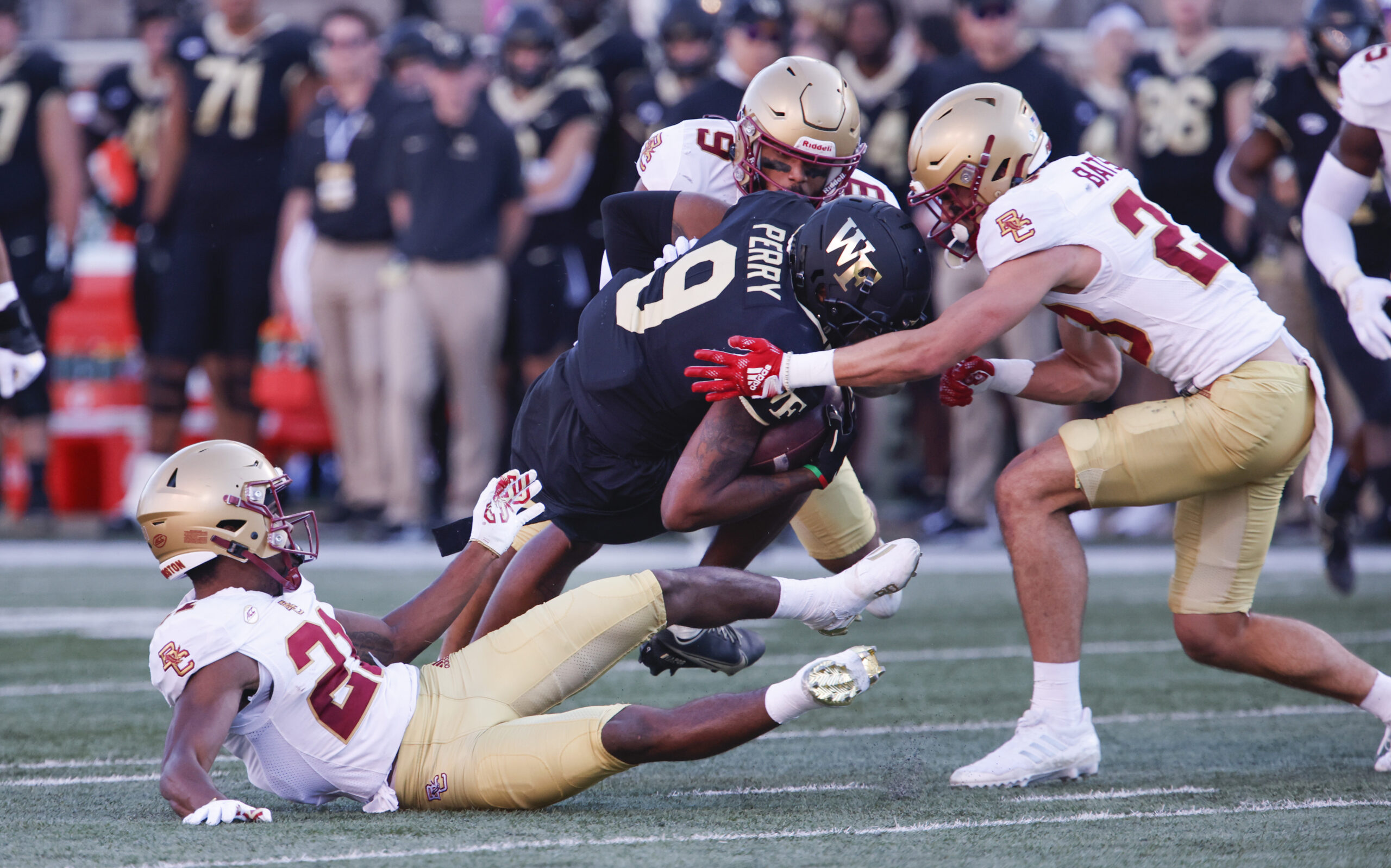 Oct 22, 2022; Winston-Salem, North Carolina, USA; Boston College Eagles defensive back Josh DeBerry (bottom left) and defensive back Cole Batson (right) and defensive back Jaiden Woodbey (9) tackle Wake Forest Demon Deacons wide receiver A.T. Perry (9) during the second quarter at Truist Field. Mandatory Credit: Reinhold Matay-Imagn Images