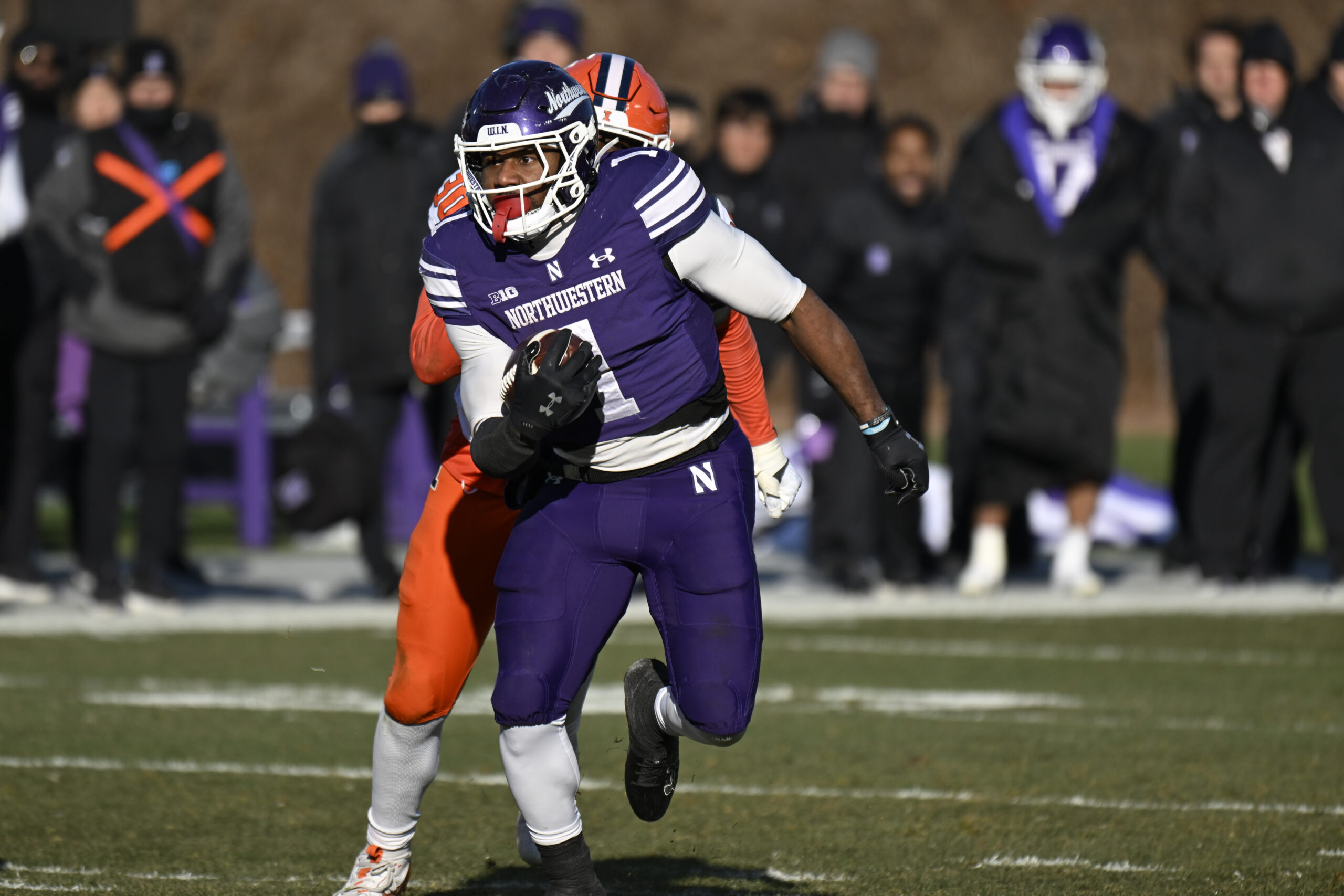 Nov 30, 2024; Chicago, Illinois, USA; Northwestern Wildcats running back Cam Porter (1) runs the ball against the Illinois Fighting Illini during the second half at Wrigley Field. Mandatory Credit: Matt Marton-Imagn Images