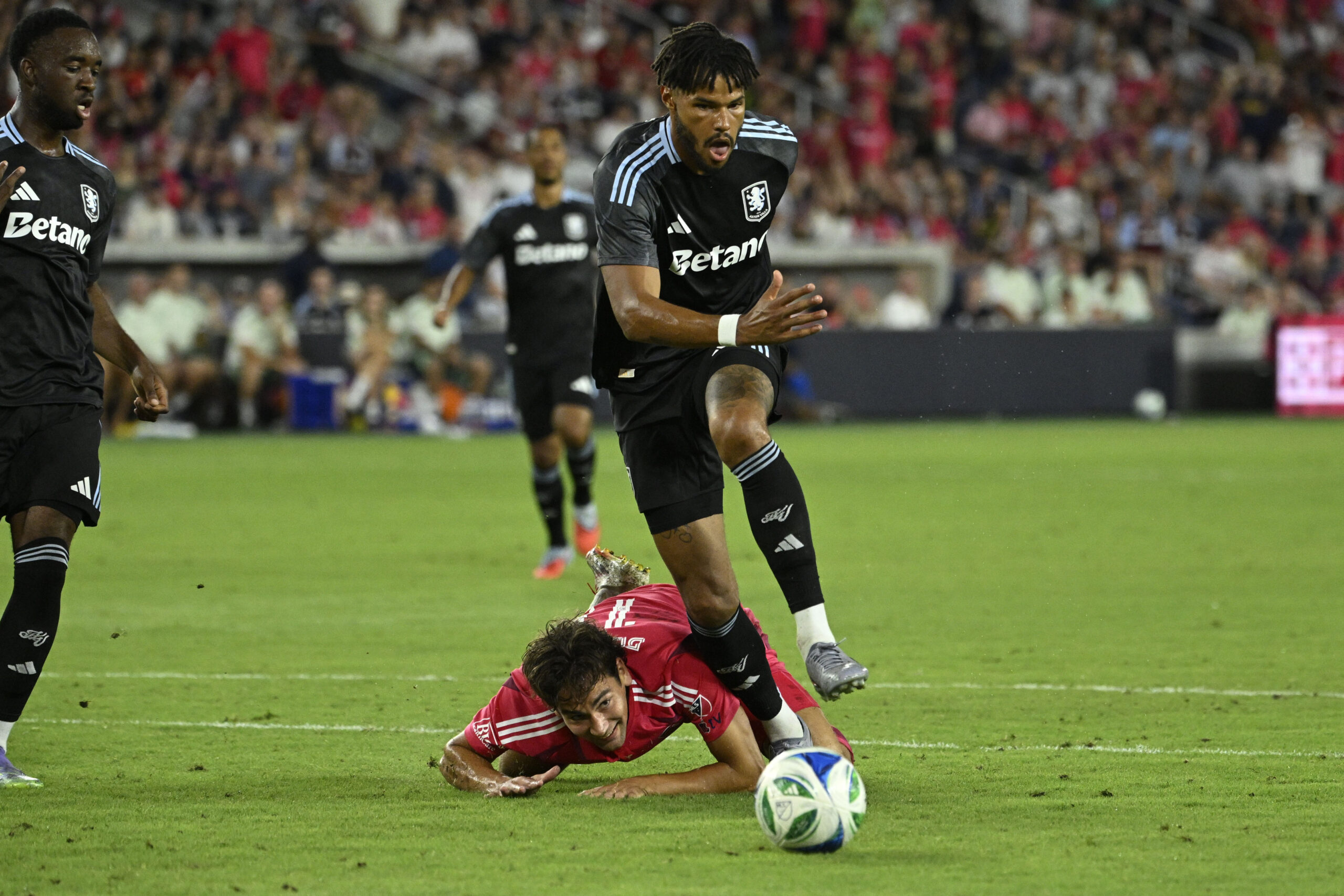 Jul 30, 2025; St. Louis, Missouri, USA; St. Louis City forward Simon Becher (11) falls to the pitch while battling Aston Villa defender Tyrone Mings (5) for the ball in the second half at Energizer Park. Mandatory Credit: Joe Puetz-Imagn Images