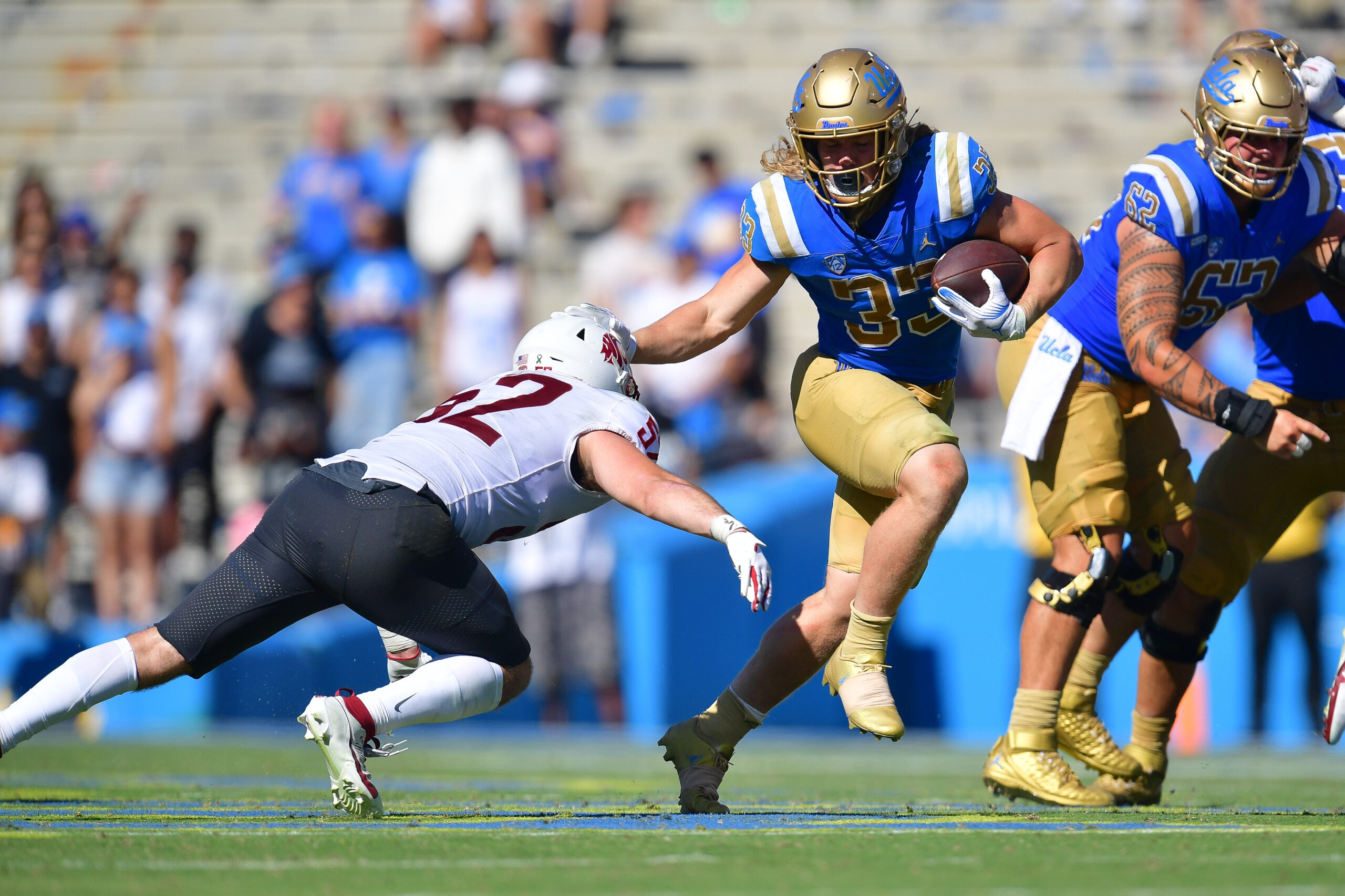 Oct 7, 2023; Pasadena, California, USA; UCLA Bruins running back Carson Steele (33) runs the ball against Washington State Cougars linebacker Kyle Thornton (52) during the second half at Rose Bowl. Mandatory Credit: Gary A. Vasquez-Imagn Images