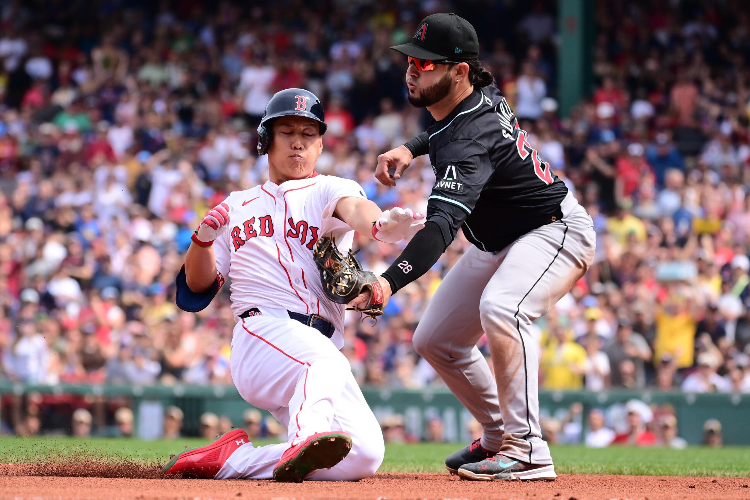 Aug 25, 2024; Boston, Massachusetts, USA; Boston Red Sox designated hitter Masataka Yoshida (7) is tagged out by Arizona Diamondbacks third baseman Eugenio Suarez (28) during the fourth inning at Fenway Park. Mandatory Credit: Eric Canha-Imagn Images