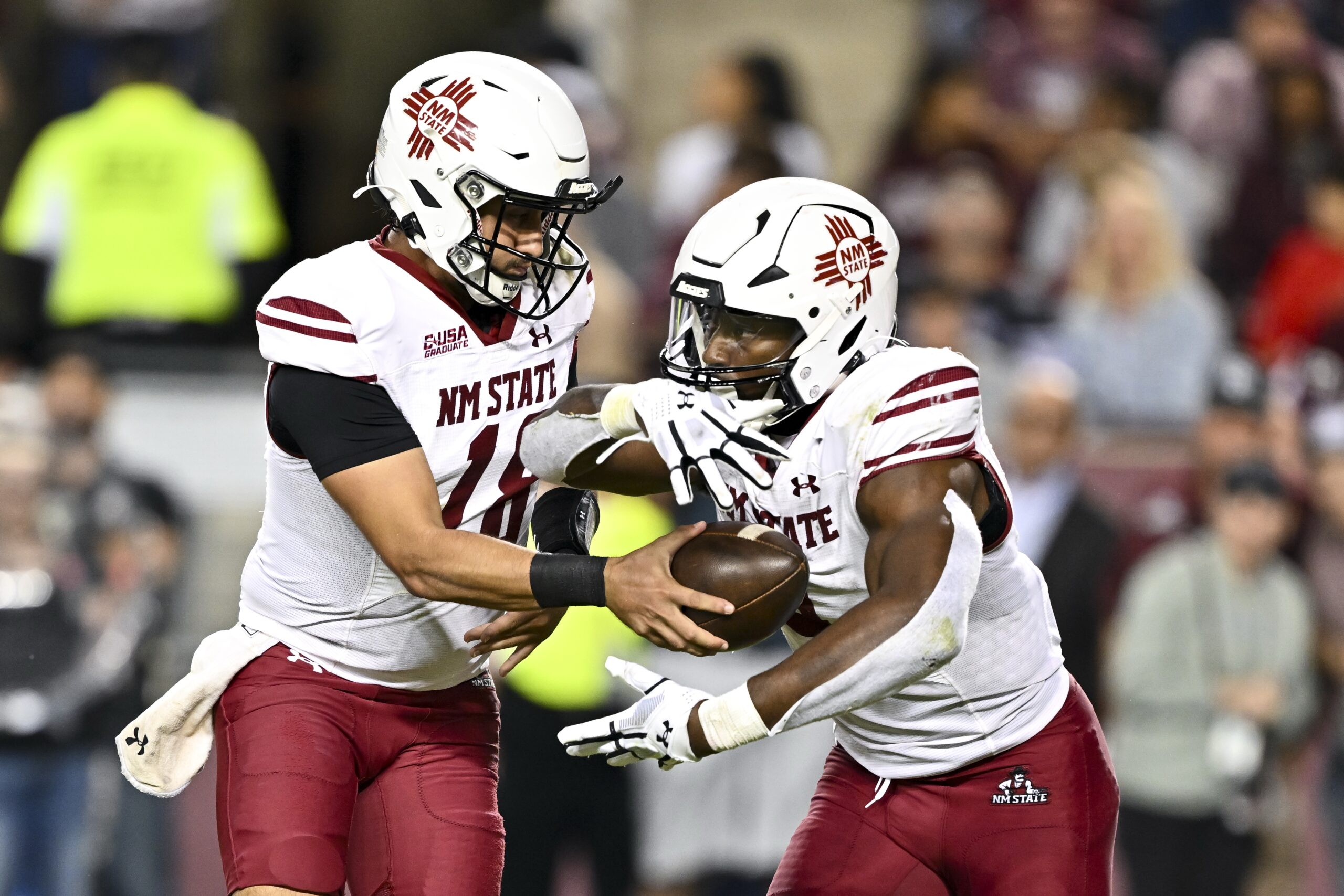Nov 16, 2024; College Station, Texas, USA; New Mexico State Aggies quarterback Santino Marucci (18) hands the ball off to running back Mike Washington (4) during the fourth quarter at Kyle Field. Mandatory Credit: Maria Lysaker-Imagn Images