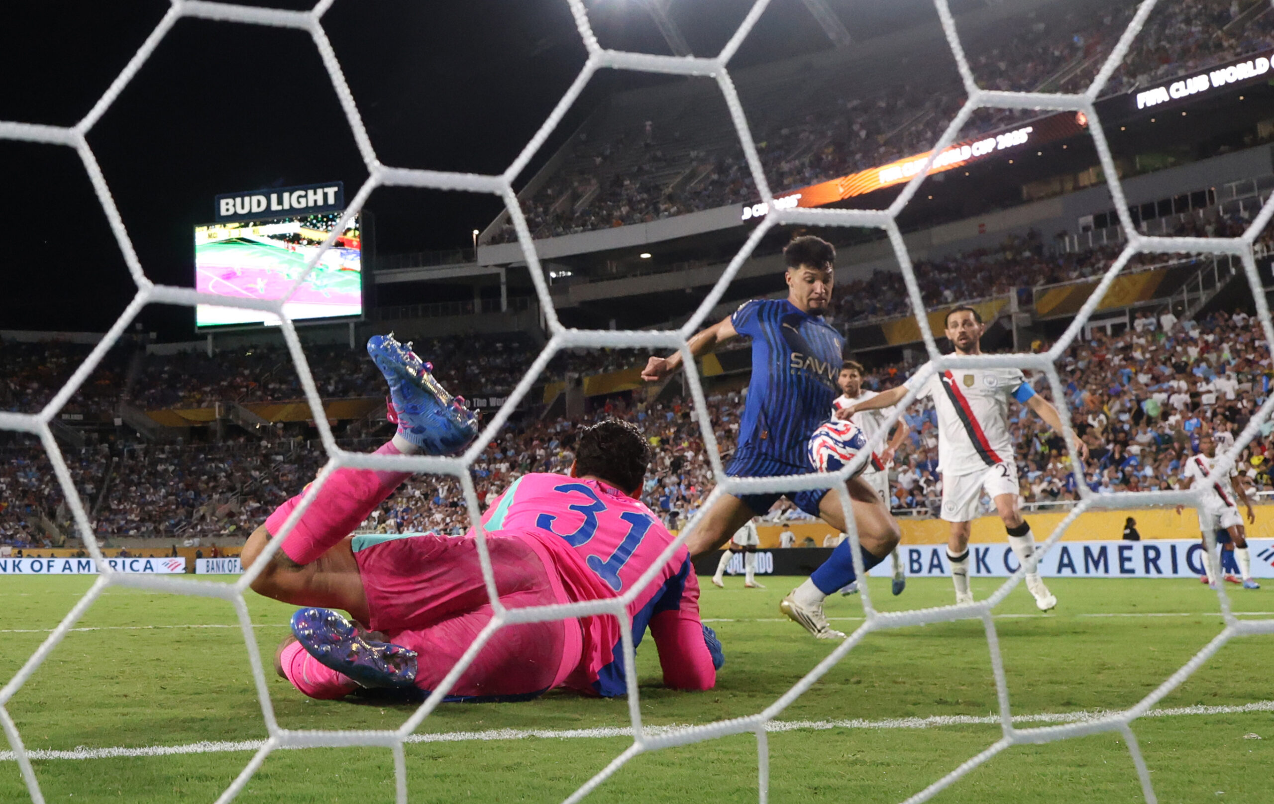 Jun 30, 2025; Orlando, Florida, USA; Al Hilal FC forward Marcos Leonardo (11) scores against Manchester City goalkeeper Ederson (31) during a round of 16 match of the 2025 FIFA Club World Cup at Camping World Stadium. Mandatory Credit: Nathan Ray Seebeck-Imagn Images