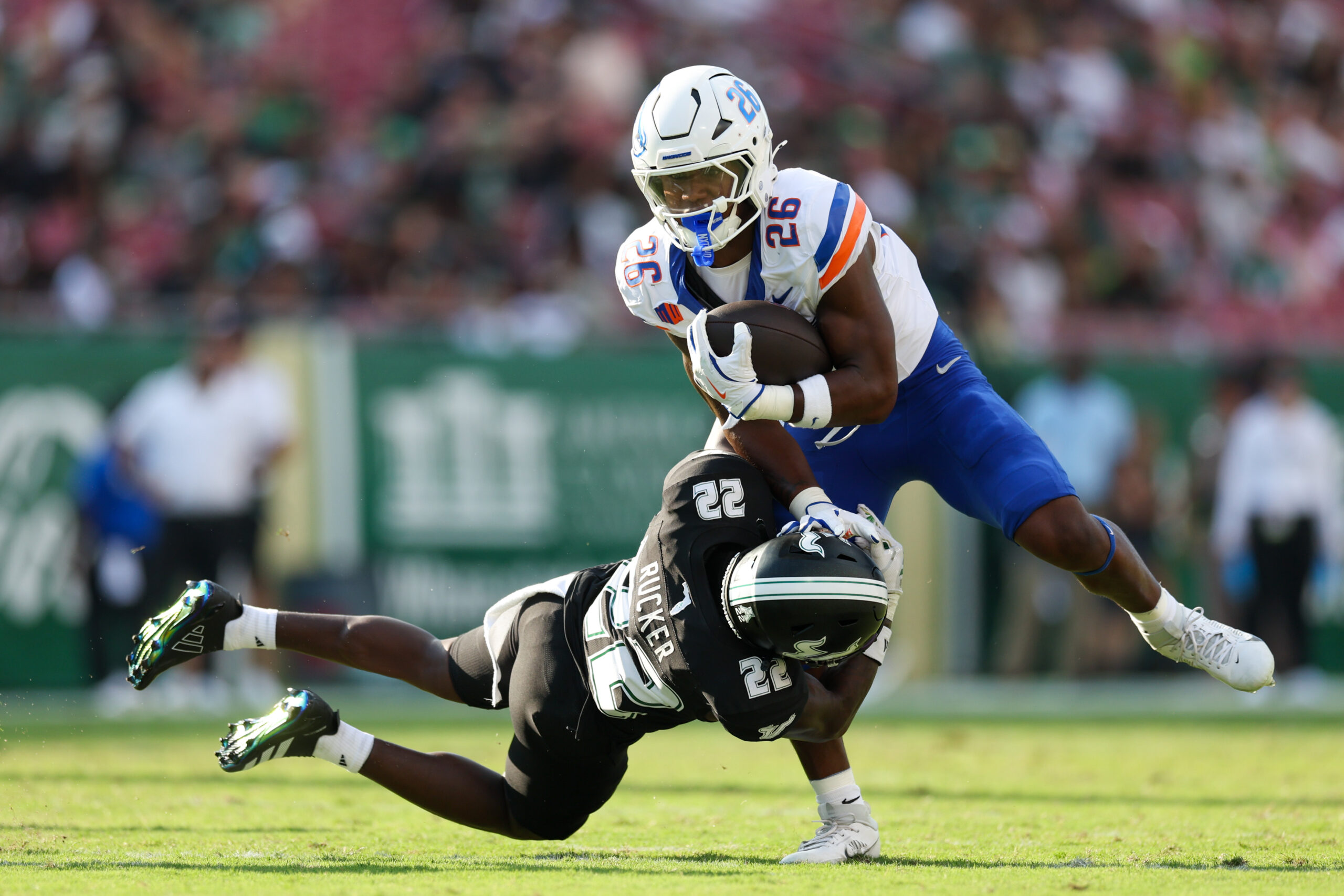 Aug 28, 2025; Tampa, Florida, USA; Boise State Broncos running back Sire Gaines (26) holds off South Florida Bulls cornerback De'Shawn Rucker (22) in the first quarter at Raymond James Stadium. Mandatory Credit: Nathan Ray Seebeck-Imagn Images