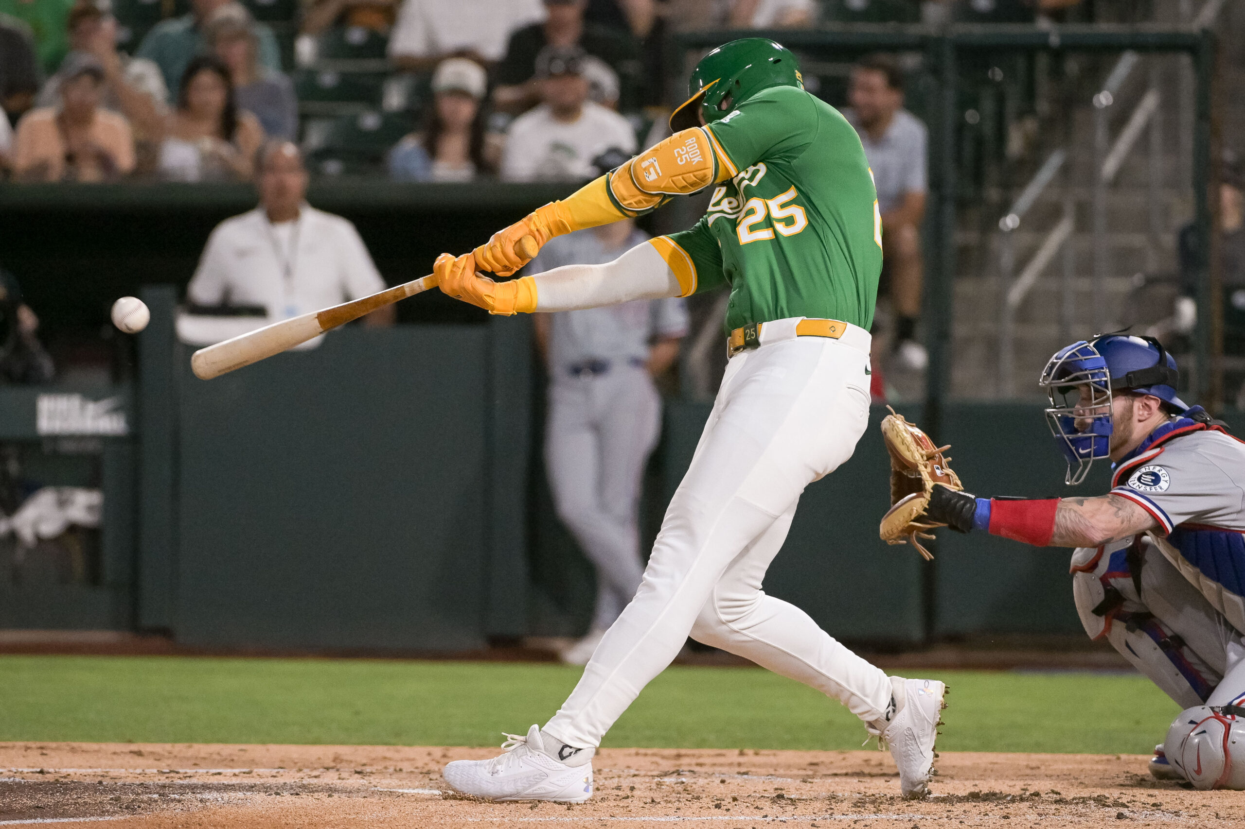 Aug 29, 2025; West Sacramento, California, USA; Athletics outfielder Brent Rooker (25) hits an rbi double against the Texas Rangers during the third inning at Sutter Health Park. Mandatory Credit: Ed Szczepanski-Imagn Images