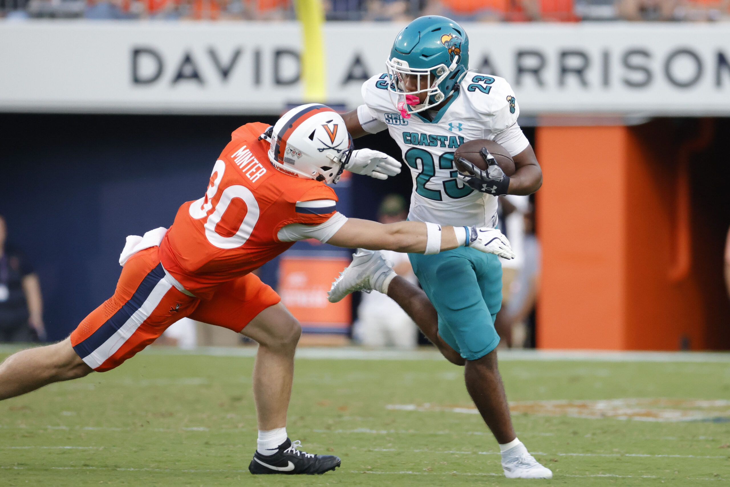 Aug 30, 2025; Charlottesville, Virginia, USA; Coastal Carolina Chanticleers running back Dominic Knicely (23) carries the ball as Virginia Cavaliers safety Ethan Minter (30) during the second quarter at Scott Stadium. Mandatory Credit: Amber Searls-Imagn Images