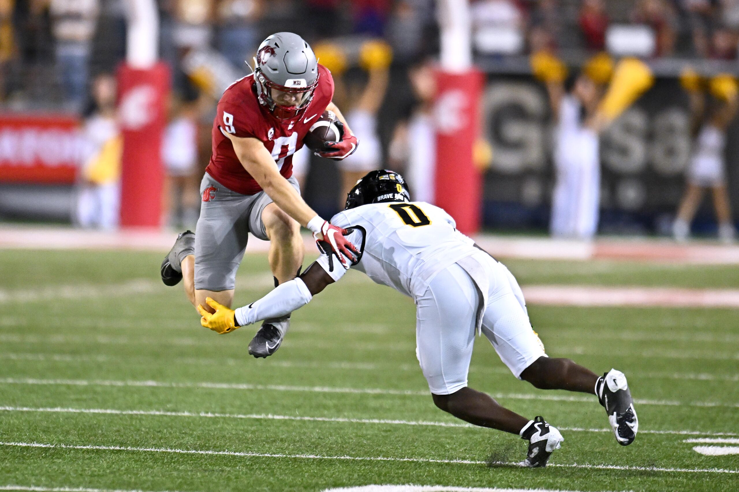 Aug 30, 2025; Pullman, Washington, USA; Washington State Cougars running back Kirby Vorhees (9) tries to jump pass Idaho Vandals defensive back Jhamell Blenman (0) in the second half at Gesa Field at Martin Stadium. Washington State Cougars won 13-10. Mandatory Credit: James Snook-Imagn Images