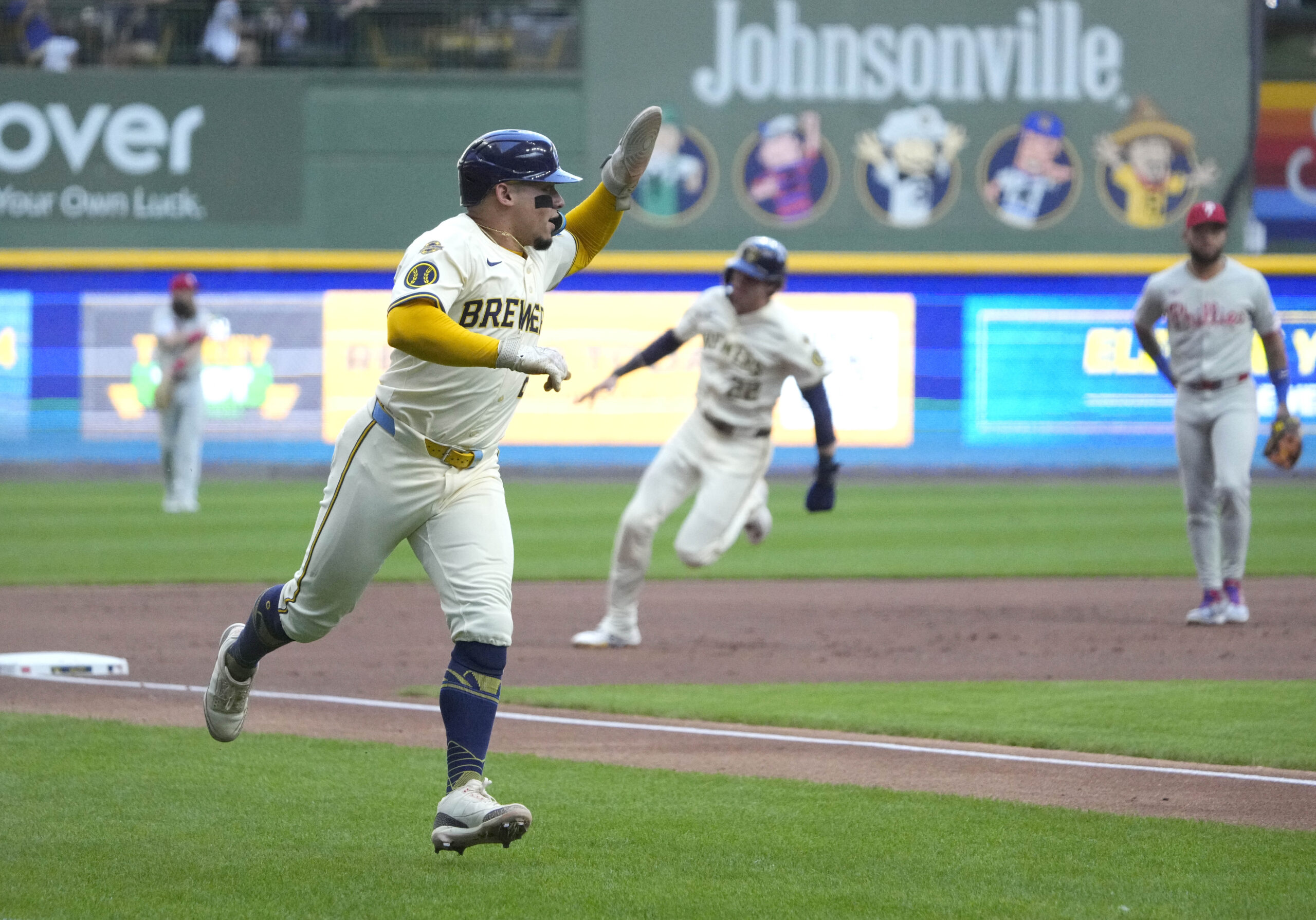 Sep 1, 2025; Milwaukee, Wisconsin, USA; Milwaukee Brewers catcher William Contreras (24) rounds third base with outfielder Christian Yelich (22) right behind him against the Philadelphia Phillies in the first inning at American Family Field. Mandatory Credit: Michael McLoone-Imagn Images