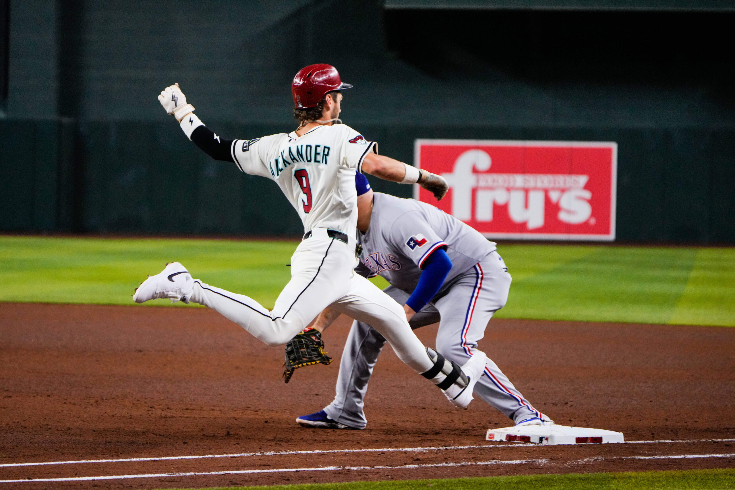 Sep 2, 2025; Phoenix, Arizona, USA; Arizona Diamondbacks shortstop Blaze Alexander (9) gets safely on base in the fourth inning of the game between Arizona Diamondbacks and Texas Rangers at Chase Field. Mandatory Credit: Arianna Grainey-Imagn Images