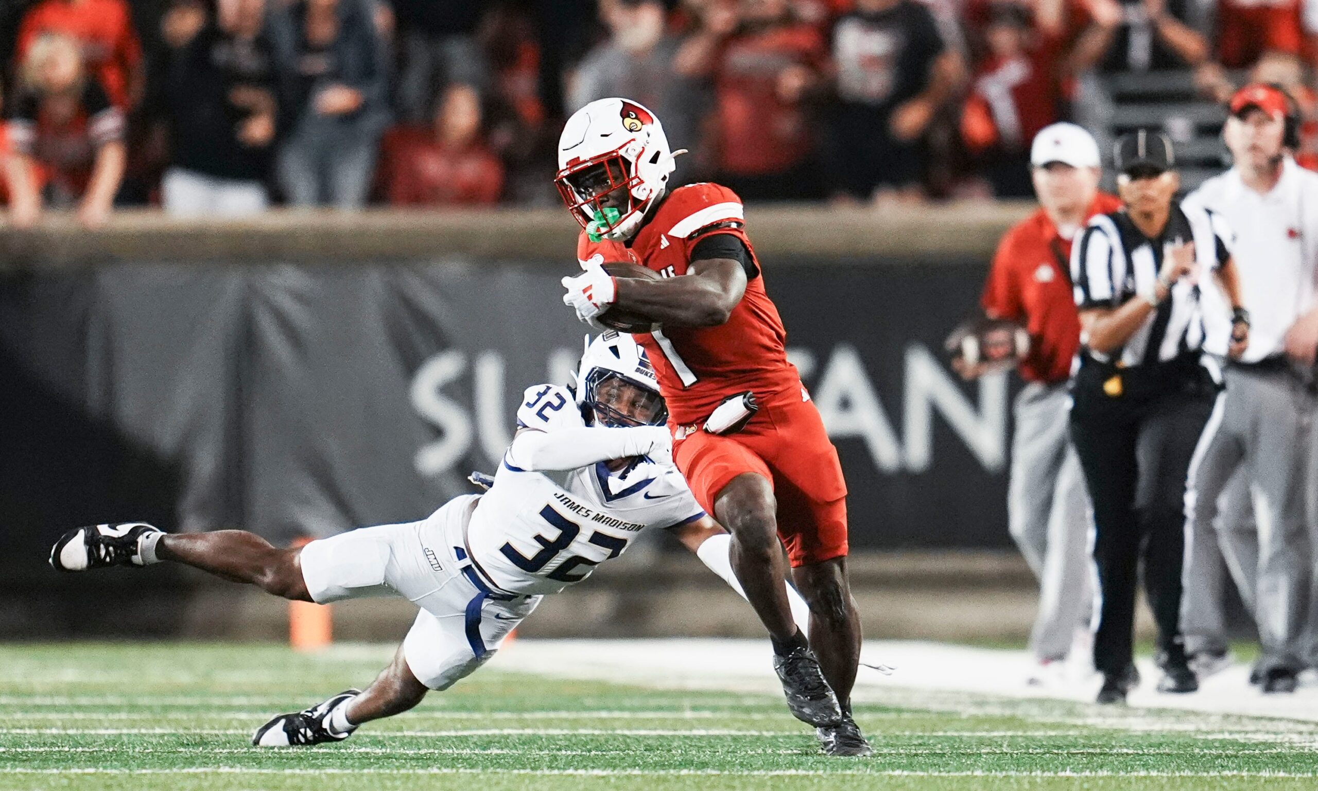Louisville Cardinals running back Isaac Brown (1) breaks away from James Madison Dukes defensive back DJ Barksdale (32) to score a big fourth quarter touchdown against James Madison during the Cards' second college football game Friday September 5, 2025 at L&N Credit Union Stadium in Louisville, Kentucky. The Cards beat the Dukes 28-14.