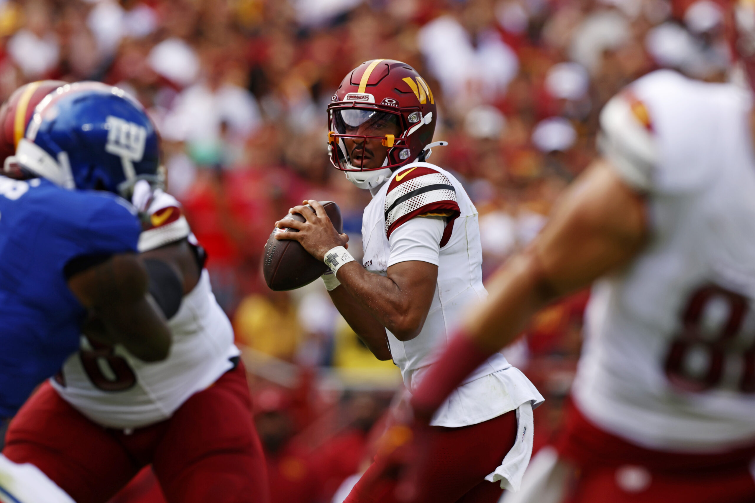Sep 7, 2025; Landover, Maryland, USA; Washington Commanders quarterback Jayden Daniels (5) drops back to pass during the first quarter against the New York Giants at Northwest Stadium. Mandatory Credit: Peter Casey-Imagn Images