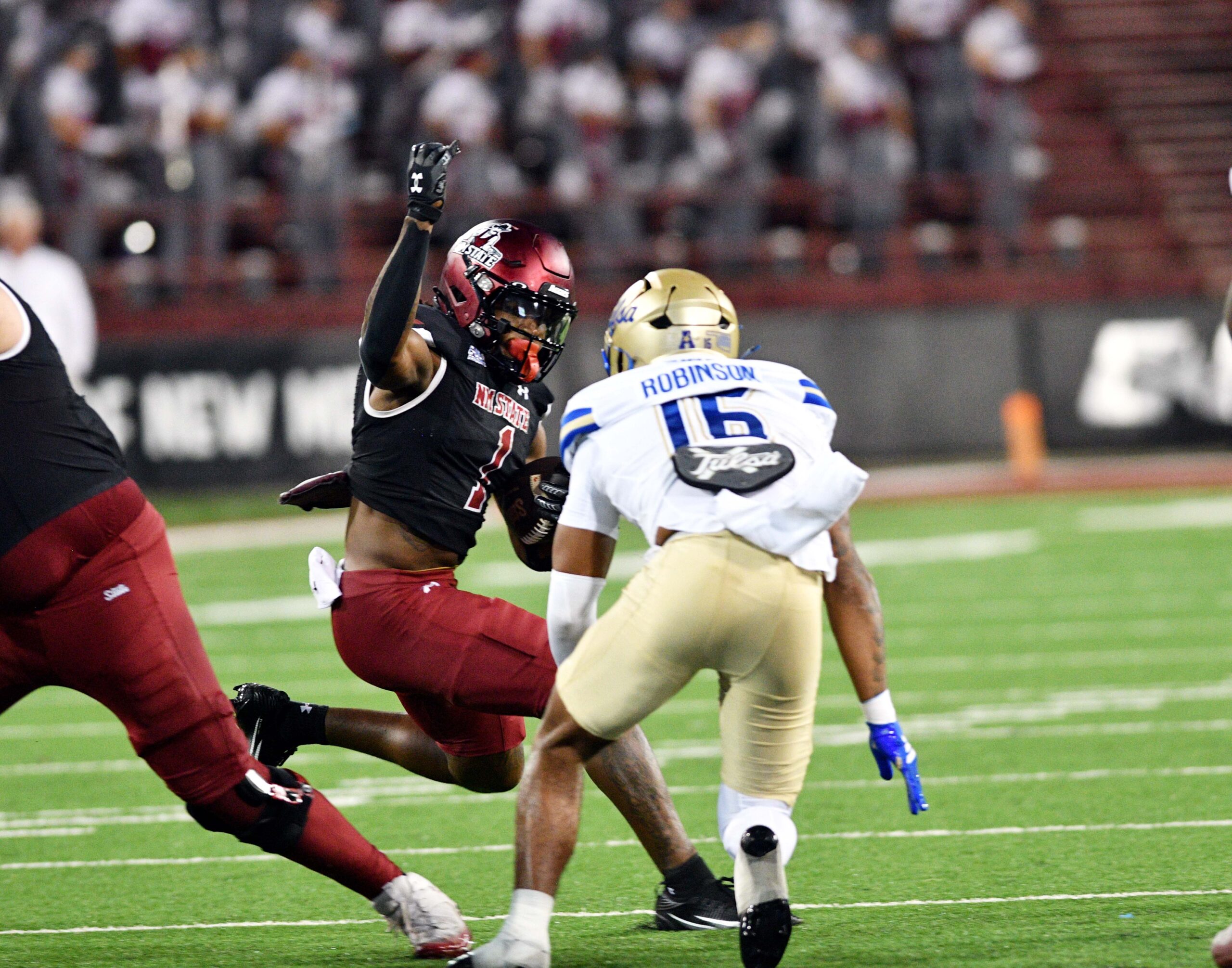 Aggie Kadarius Calloway (1) attempts to get around a Tulsa defender as NMSU took on the University of Tulsa Golden Hurricane on Saturday in Las Cruces.