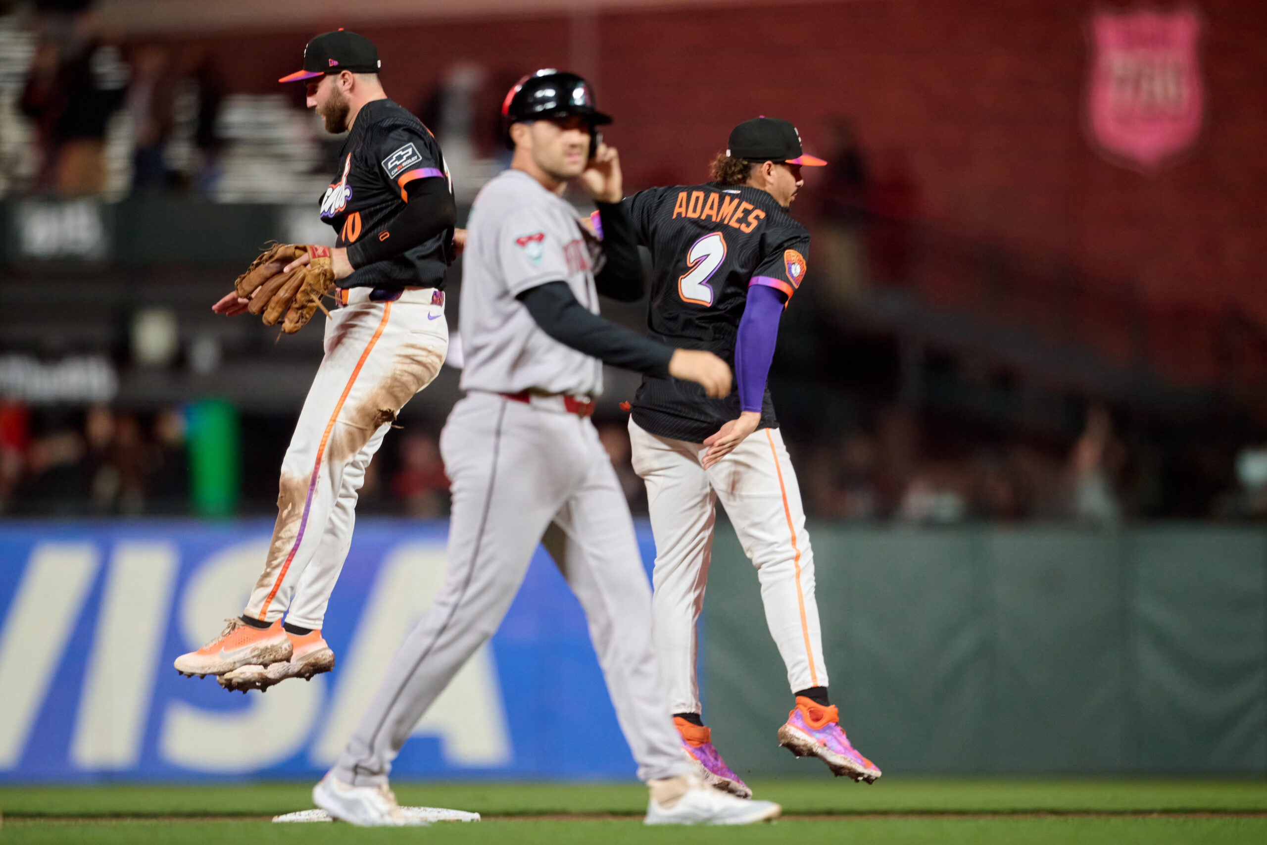 Sep 9, 2025; San Francisco, California, USA; San Francisco Giants infielders Casey Schmitt (10) and Willy Adames (2) leap to celebrate as Arizona Diamondbacks catcher Adrian Del Castillo (25) walks off the field after the last out of the game at Oracle Park. Mandatory Credit: Robert Edwards-Imagn Images
