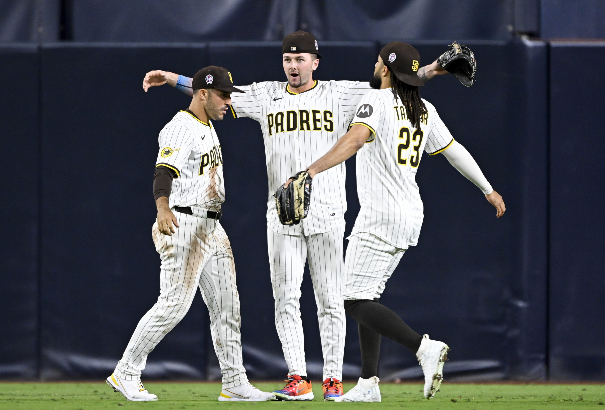 Sep 11, 2025; San Diego, California, USA; San Diego Padres right fielder Ramon Laureano (5), left, Jackson Merrill (3), center, and  Fernando Tatis Jr. (23) celebrate after the Padres defeated the Colorado Rockies at Petco Park. Mandatory Credit: Denis Poroy-Imagn Images