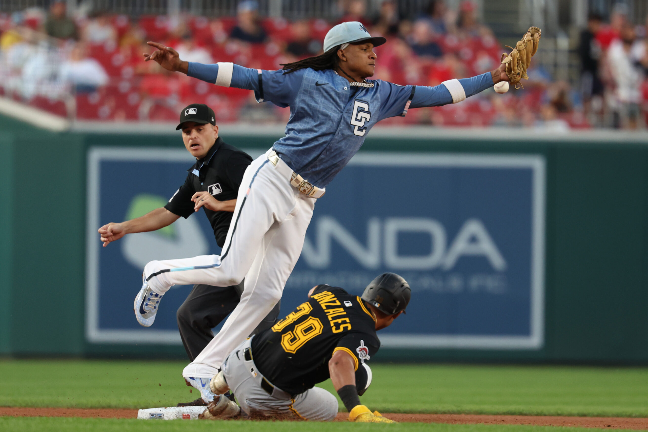 Sep 12, 2025; Washington, District of Columbia, USA; Pittsburgh Pirates second base Nick Gonzales (39) slides into second base as a throw by Washington Nationals first base Josh Bell (not pictured) on a ground ball by Pirates outfielder Oneil Cruz (not pictured) sails past Nationals shortstop CJ Abrams (5) during the second inning at Nationals Park. Mandatory Credit: Geoff Burke-Imagn Images