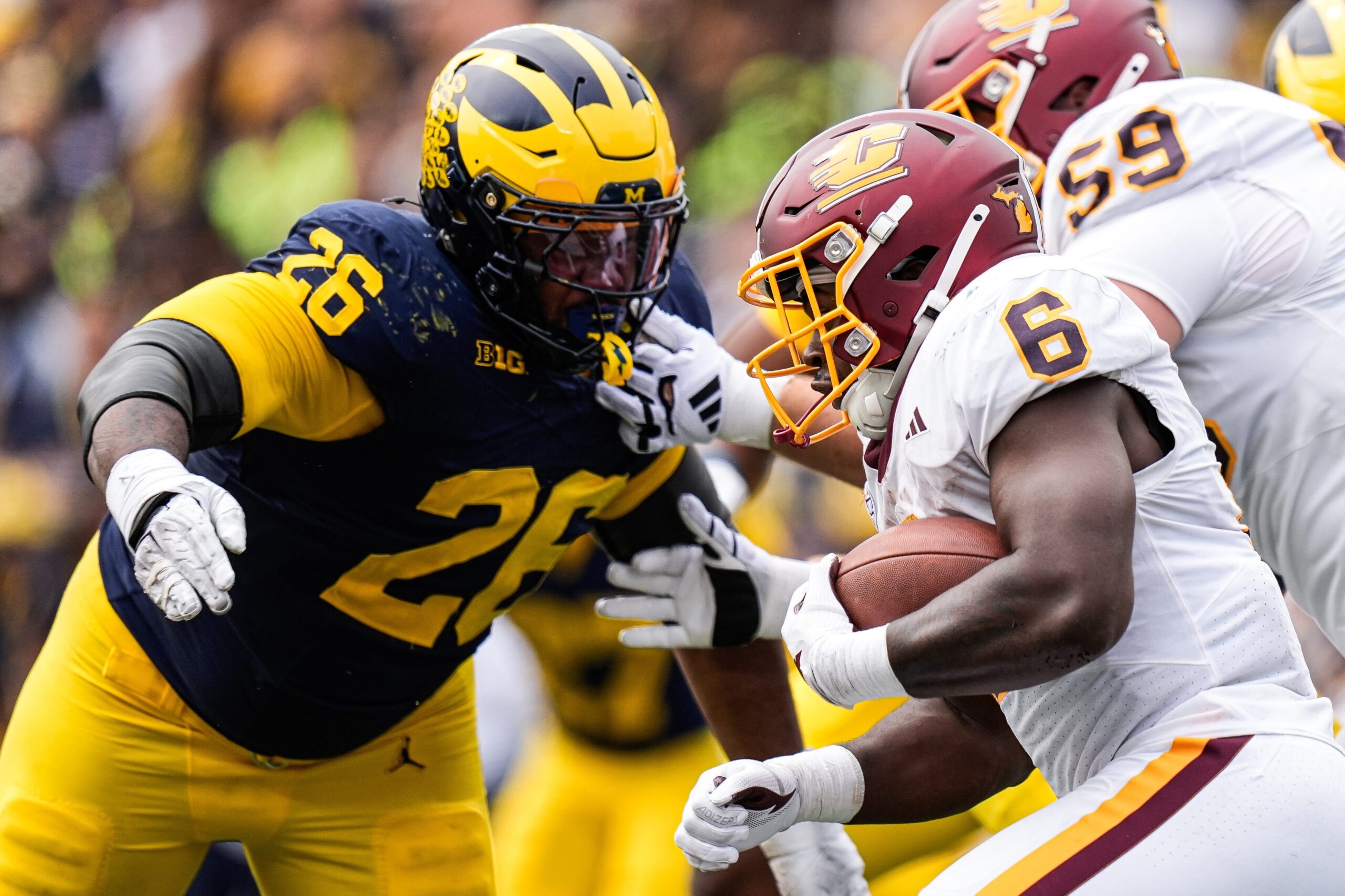Michigan defensive lineman Rayshaun Benny (26) tries to tackle Central Michigan running back Trey Cornist (6) during the second half at Michigan Stadium in Ann Arbor on Saturday, Sept. 13, 2025.