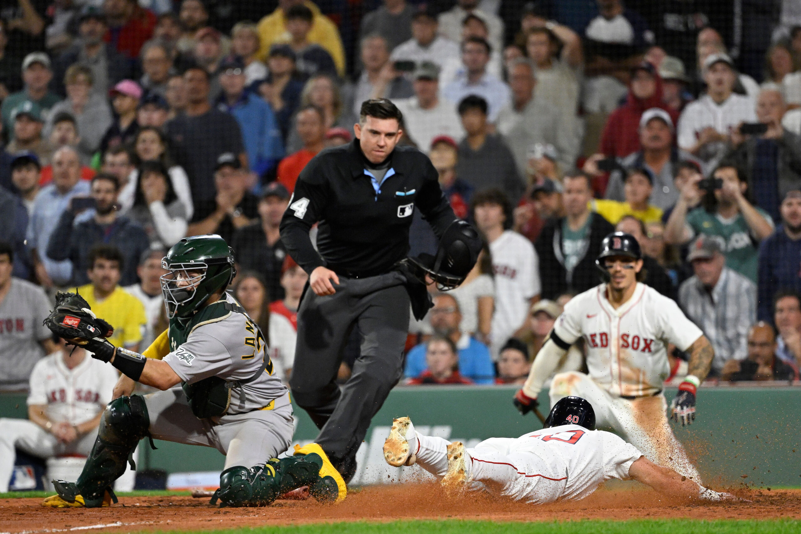 Sep 17, 2025; Boston, Massachusetts, USA; Boston Red Sox third baseman Nate Eaton (40) slides across home plate against Athletics catcher Shea Langeliers (23) to score the winning run off an RBI by first baseman Nick Sogard (20) (not pictured) during the tenth inning at Fenway Park. Mandatory Credit: Eric Canha-Imagn Images