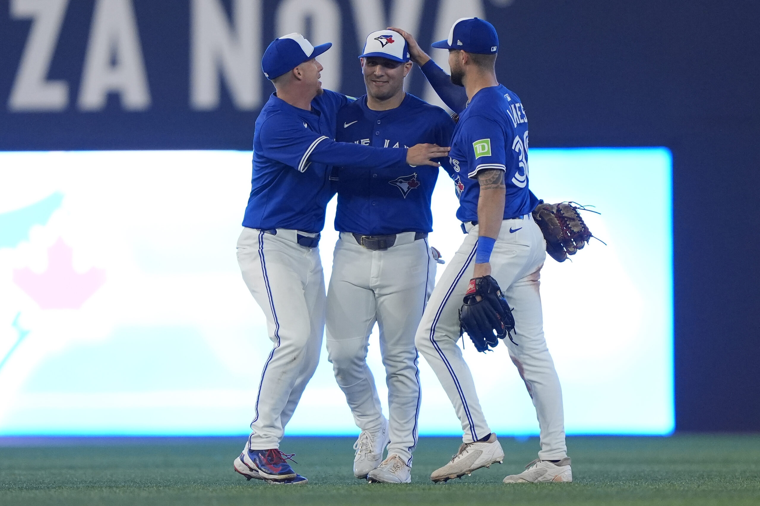 Sep 25, 2025; Toronto, Ontario, CAN; Toronto Blue Jays left fielder Anthony Santander (left) and center fielder Daulton Varsho (center) and right fielder Nathan Lukes (right) celebrate a win over the Boston Red Sox during the ninth inning at Rogers Centre. Mandatory Credit: John E. Sokolowski-Imagn Images
