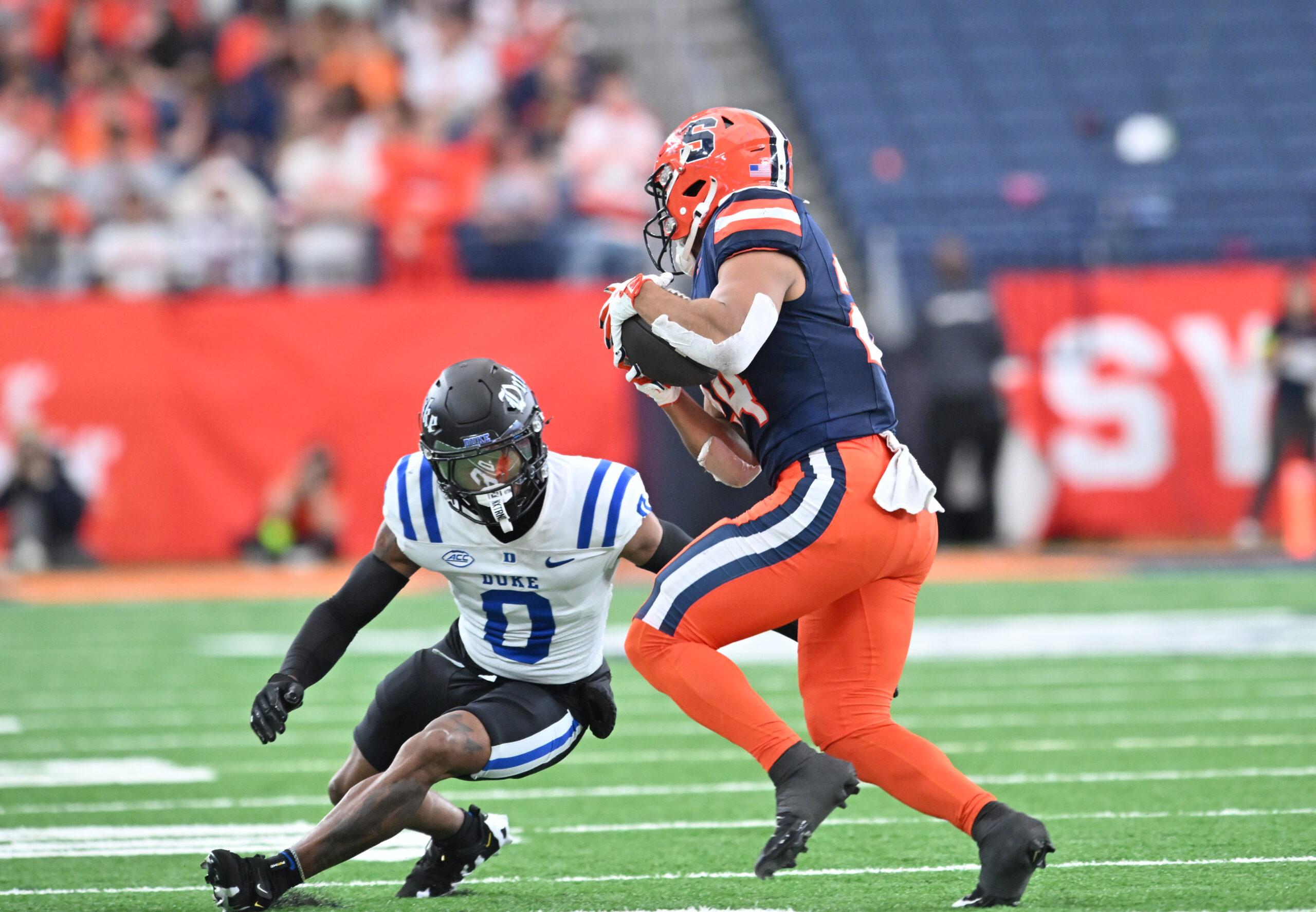 Sep 27, 2025; Syracuse, New York, USA; Duke Blue Devils cornerback Chandler Rivers (0) tries to tackle Syracuse Orange running back Will Nixon (24) in the second quarter at the JMA Wireless Dome. Mandatory Credit: Mark Konezny-Imagn Images