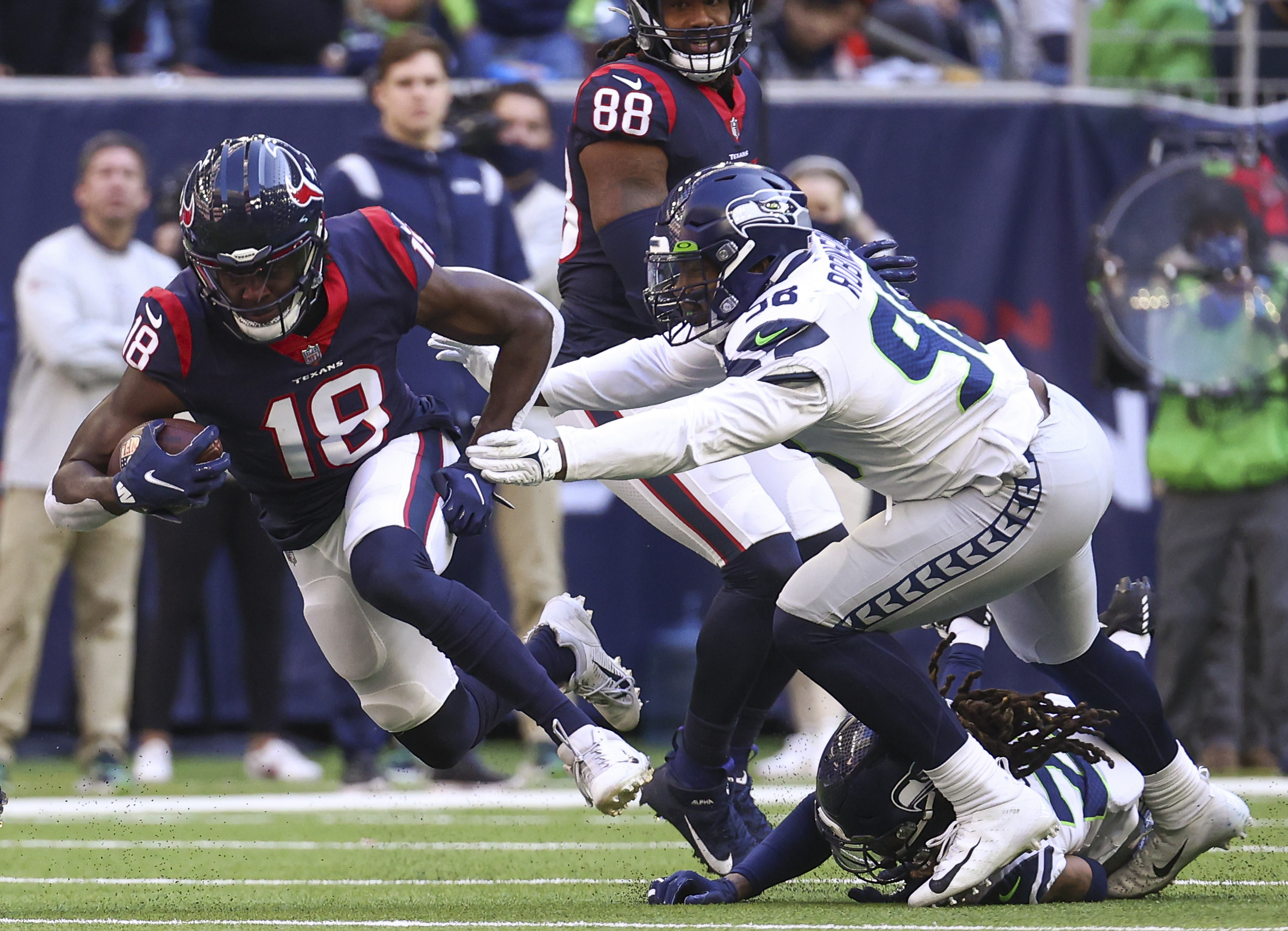 Dec 12, 2021; Houston, Texas, USA; Houston Texans wide receiver Chris Conley (18) makes a reception during the fourth quarter as Seattle Seahawks outside linebacker Alton Robinson (98) defends during the fourth quarter at NRG Stadium. Mandatory Credit: Troy Taormina-Imagn Images