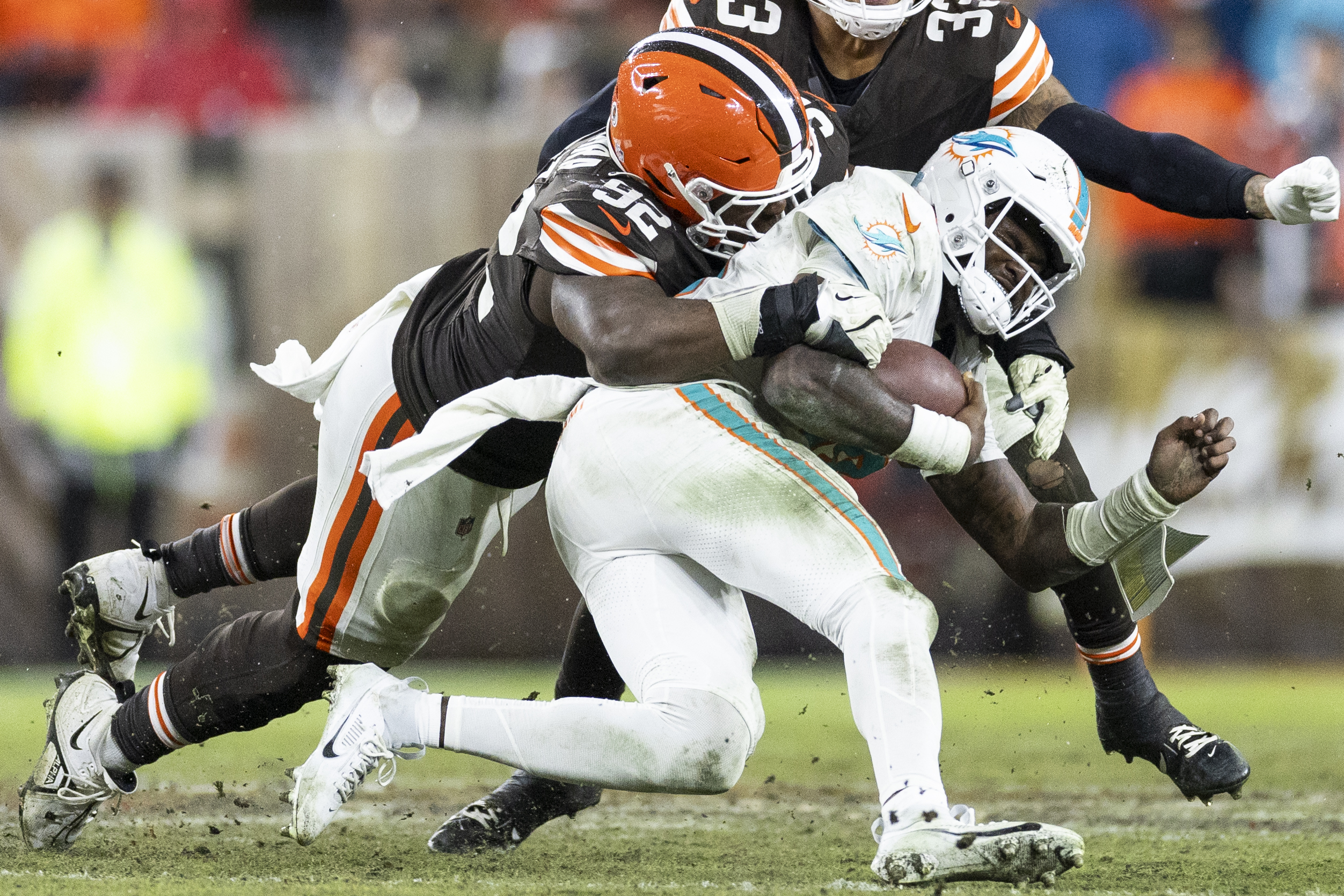 Dec 29, 2024; Cleveland, Ohio, USA; Cleveland Browns defensive end Sam Kamara (92) tackles Miami Dolphins quarterback Tyler Huntley (18) during the fourth quarter at Huntington Bank Field. Mandatory Credit: Scott Galvin-Imagn Images