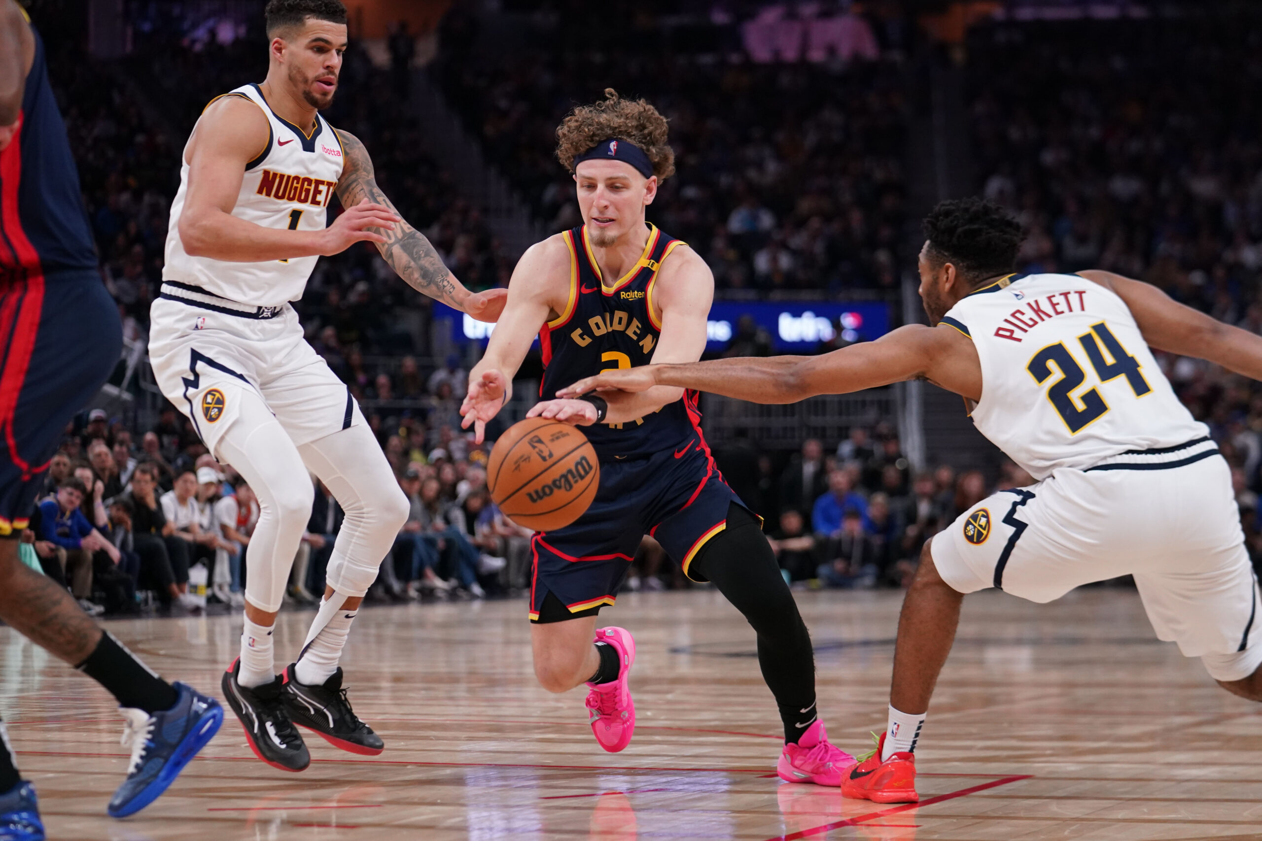 Apr 4, 2025; San Francisco, California, USA; Golden State Warriors guard Brandin Podziemski (2) dribbles by Denver Nuggets forward Michael Porter Jr. (1) and Denver Nuggets guard Jalen Pickett (24) in the third period at Chase Center. Mandatory Credit: David Gonzales-Imagn Images