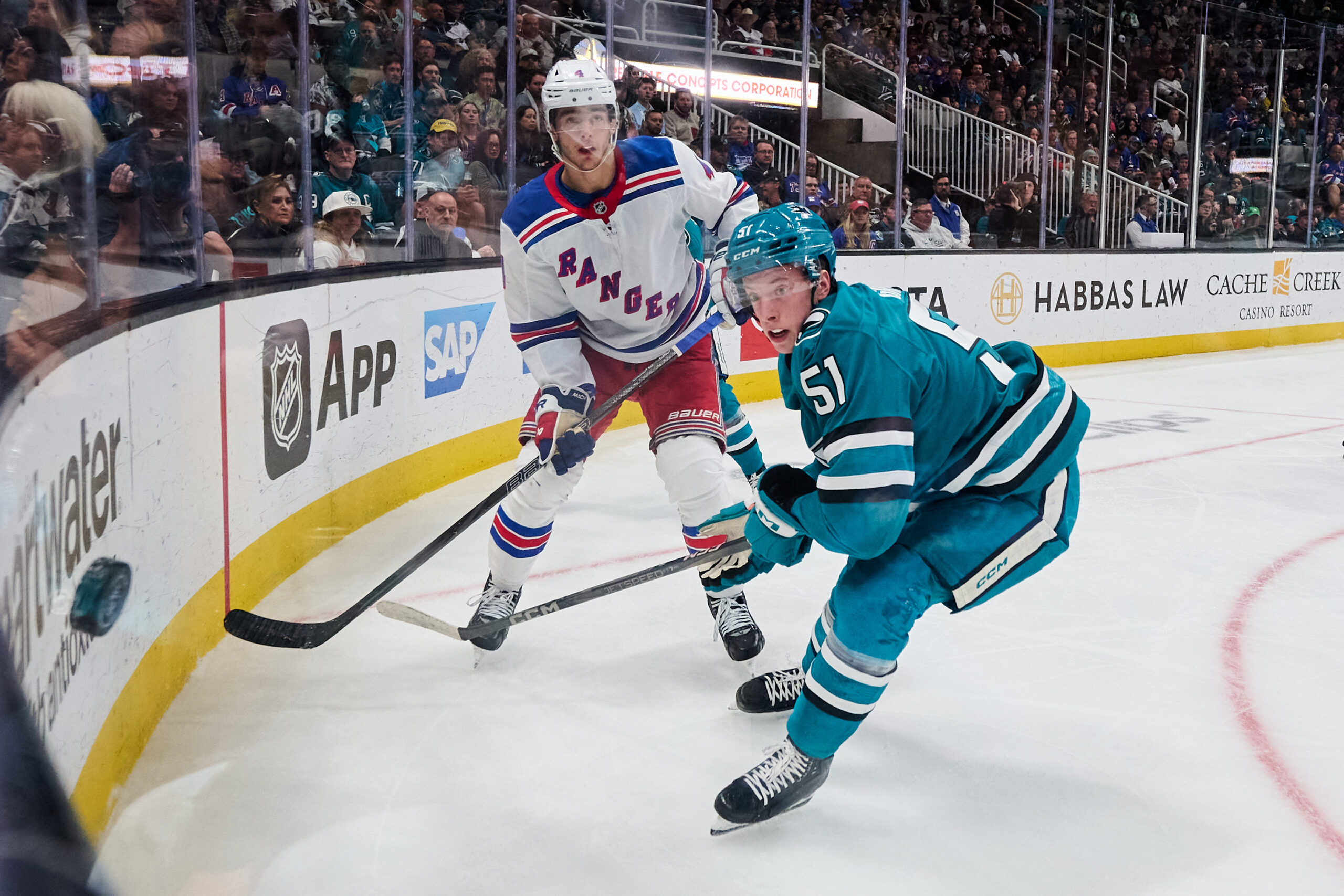 Mar 29, 2025; San Jose, California, USA; New York Rangers defenseman Braden Schneider (4) passes the puck against San Jose Sharks right wing Collin Graf (51) during the second period at SAP Center at San Jose. Mandatory Credit: Robert Edwards-Imagn Images