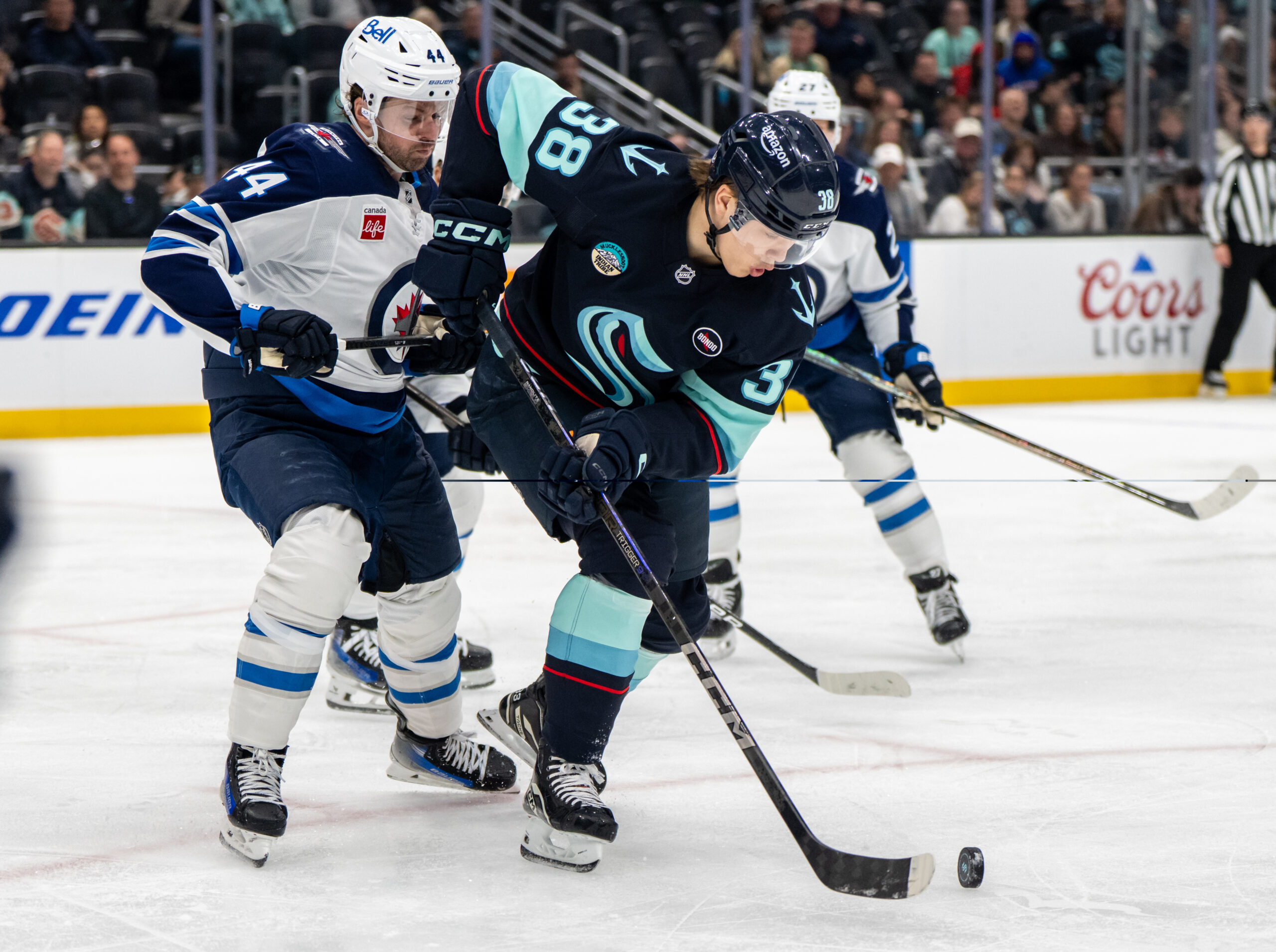 Mar 16, 2025; Seattle, Washington, USA; Seattle Kraken foward Jani Nyman (38) skates against Winnipeg Jets defenseman Josh Morrissey (44) at Climate Pledge Arena. Mandatory Credit: Stephen Brashear-Imagn Images