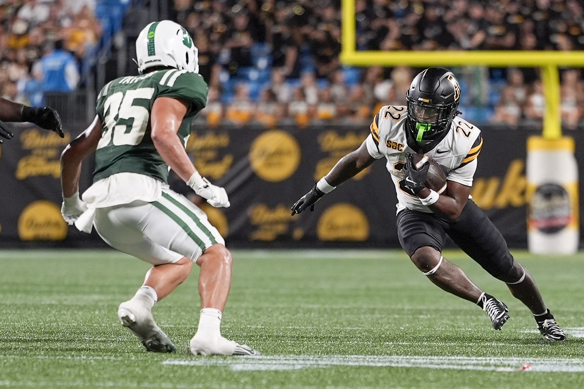 Aug 29, 2025; Charlotte, North Carolina, USA; Appalachian State Mountaineers running back Jaquari Lewis (22) tries to elude Charlotte 49ers linebacker Shay Taylor (35) during the second half at Bank of America Stadium. Mandatory Credit: Jim Dedmon-Imagn Images