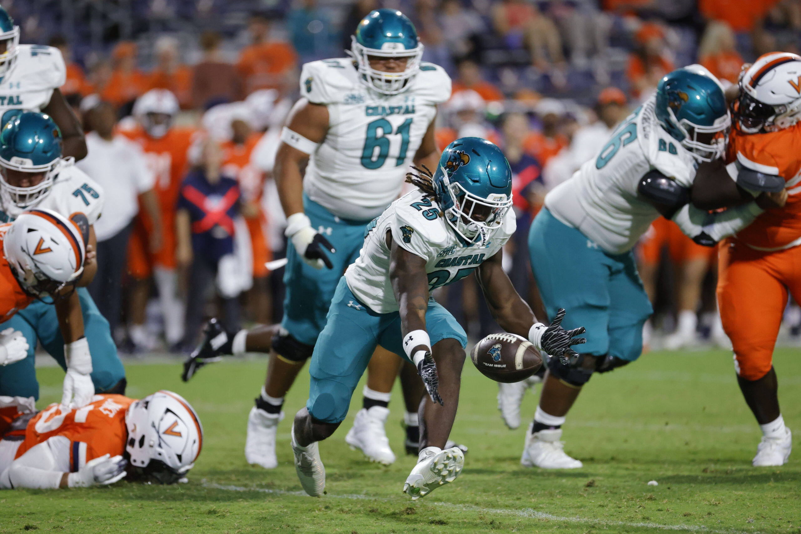 Aug 30, 2025; Charlottesville, Virginia, USA; Coastal Carolina Chanticleers running back Breyahn Townsend (25) attempts to recover a fumble against the Virginia Cavaliers during the second half at Scott Stadium. Mandatory Credit: Amber Searls-Imagn Images
